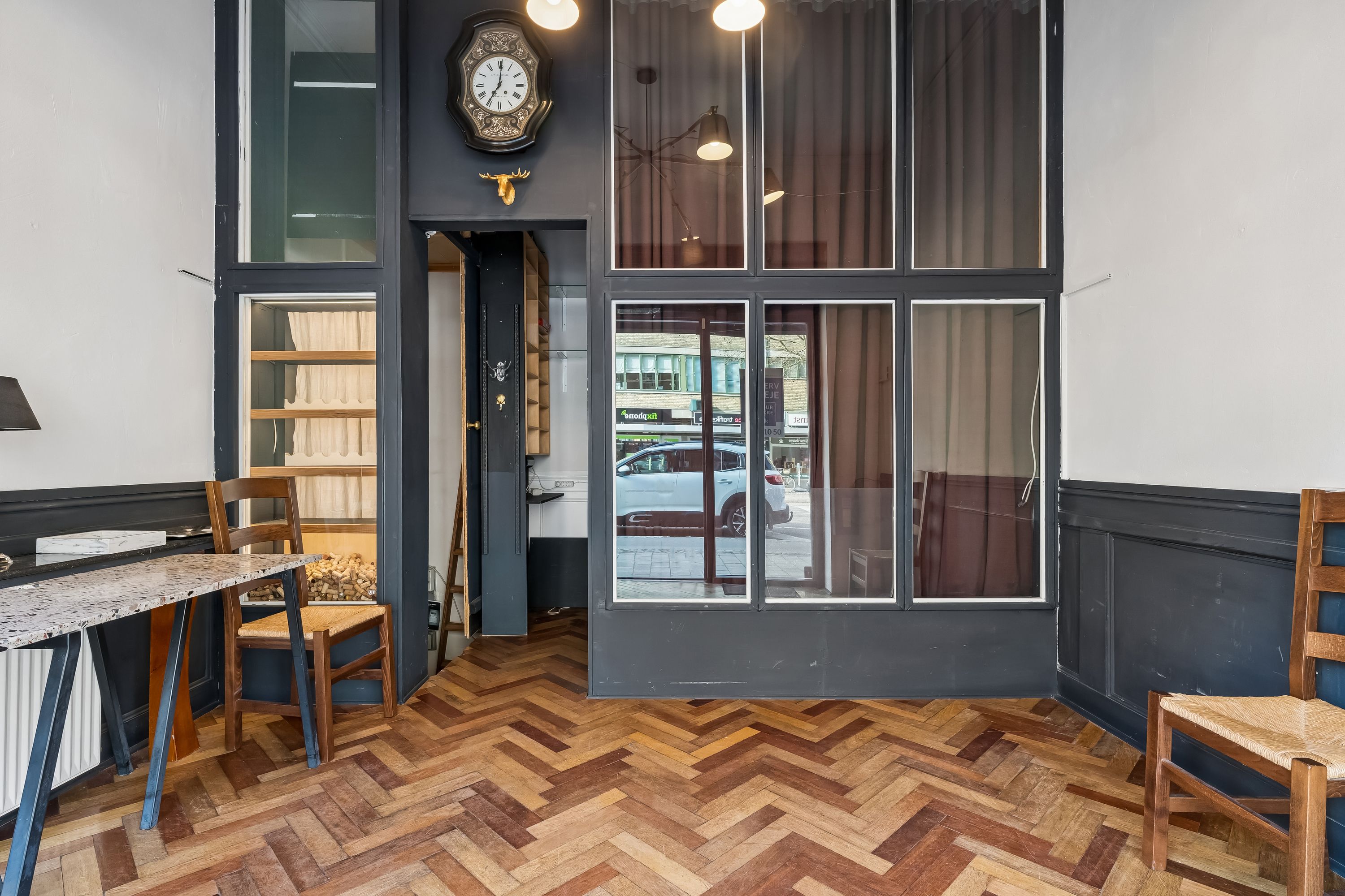 Interiør med lyse trægulve, møbler, en lysekron, gulvtæppe, køkkenbord, lysekroner, spejl og indgangsdør til lejelejlighed i Kongens Lyngby.