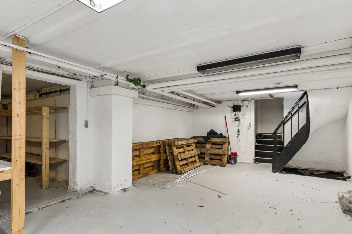 Lejligheden til leje i Kongens Lyngby har et stort kælderrum med højt til loftet, træpaller og et skråloftsvindue. Rummet er lyst og rummeligt.