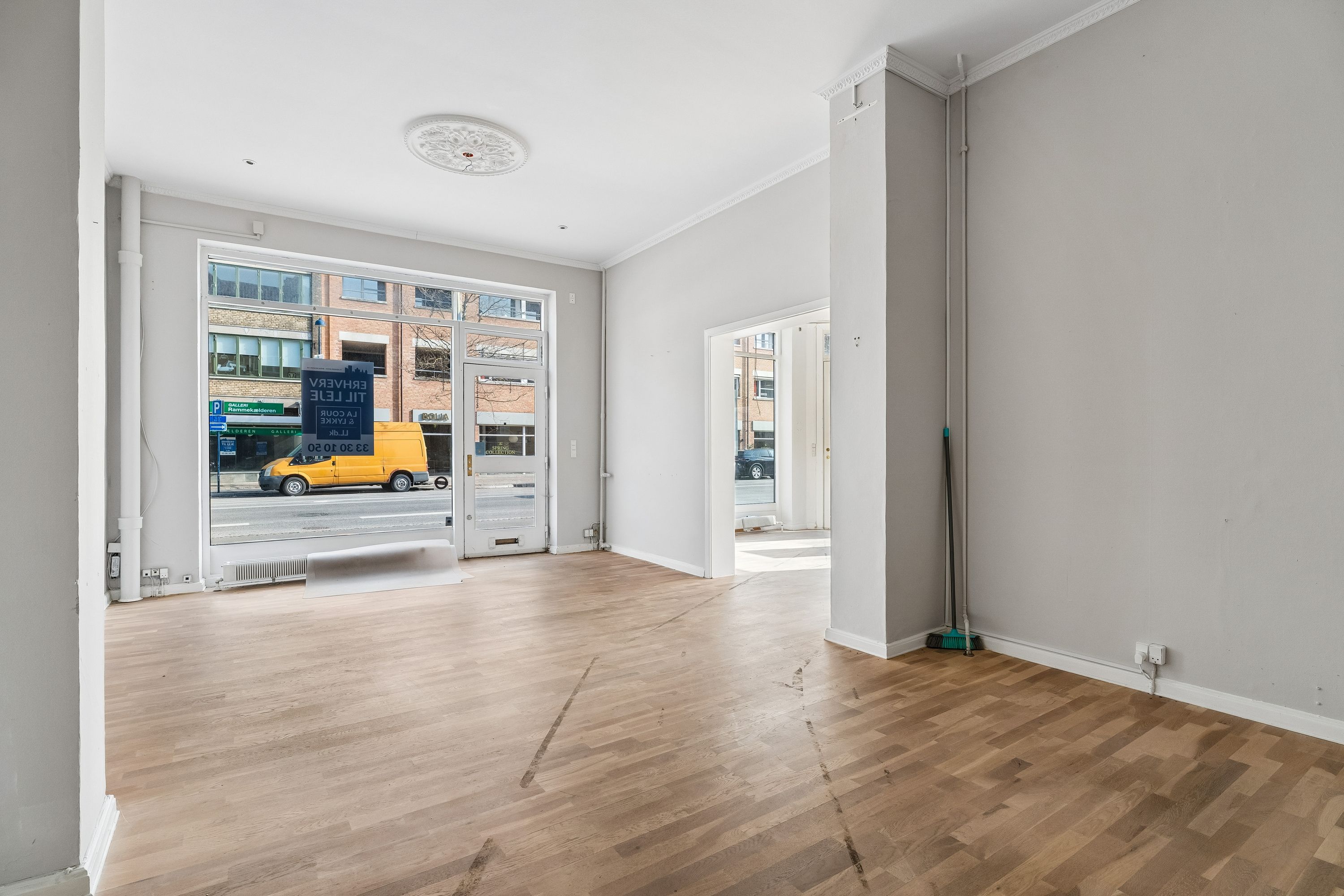 Store lejlighedslejlighed med højt loft og glasvinduer og døre til gaden og udendørsområder