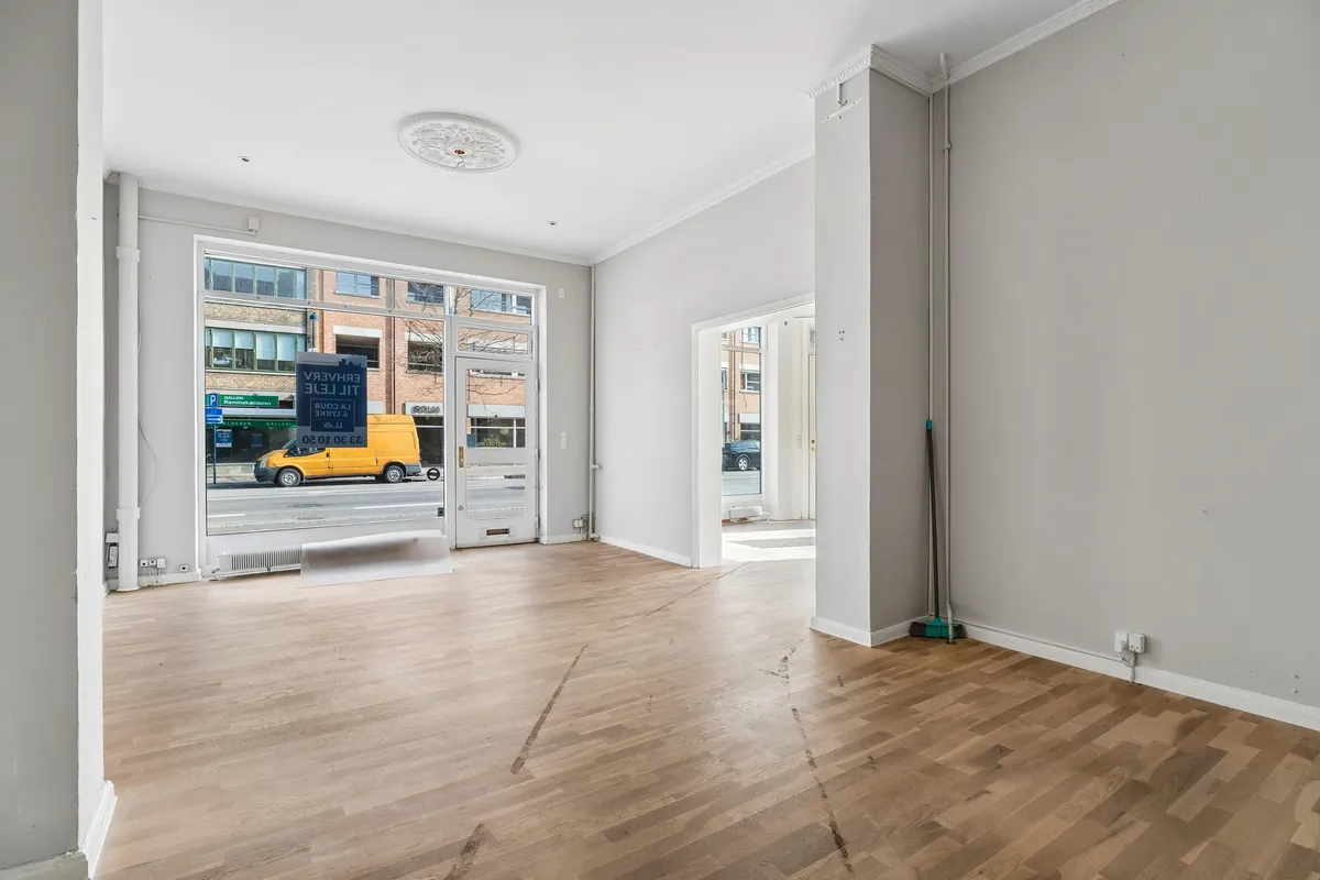 Store lejlighedslejlighed med højt loft og glasvinduer og døre til gaden og udendørsområder