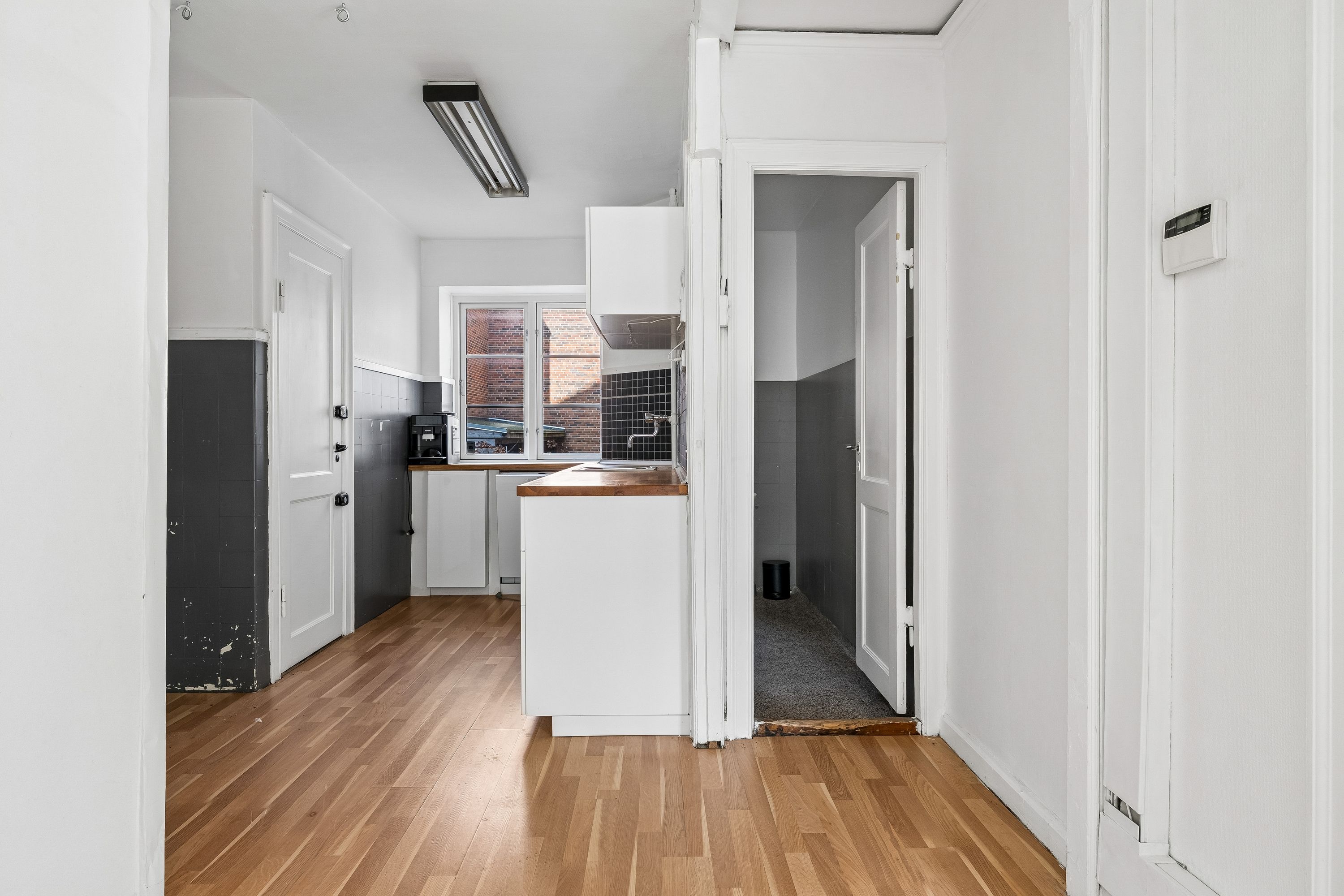 Alt-tekst: Hjørne lejemål med høj synlighed, ren køkken og luksuriøs gulv. Moderne design med hvide vægge og lyse lofter.