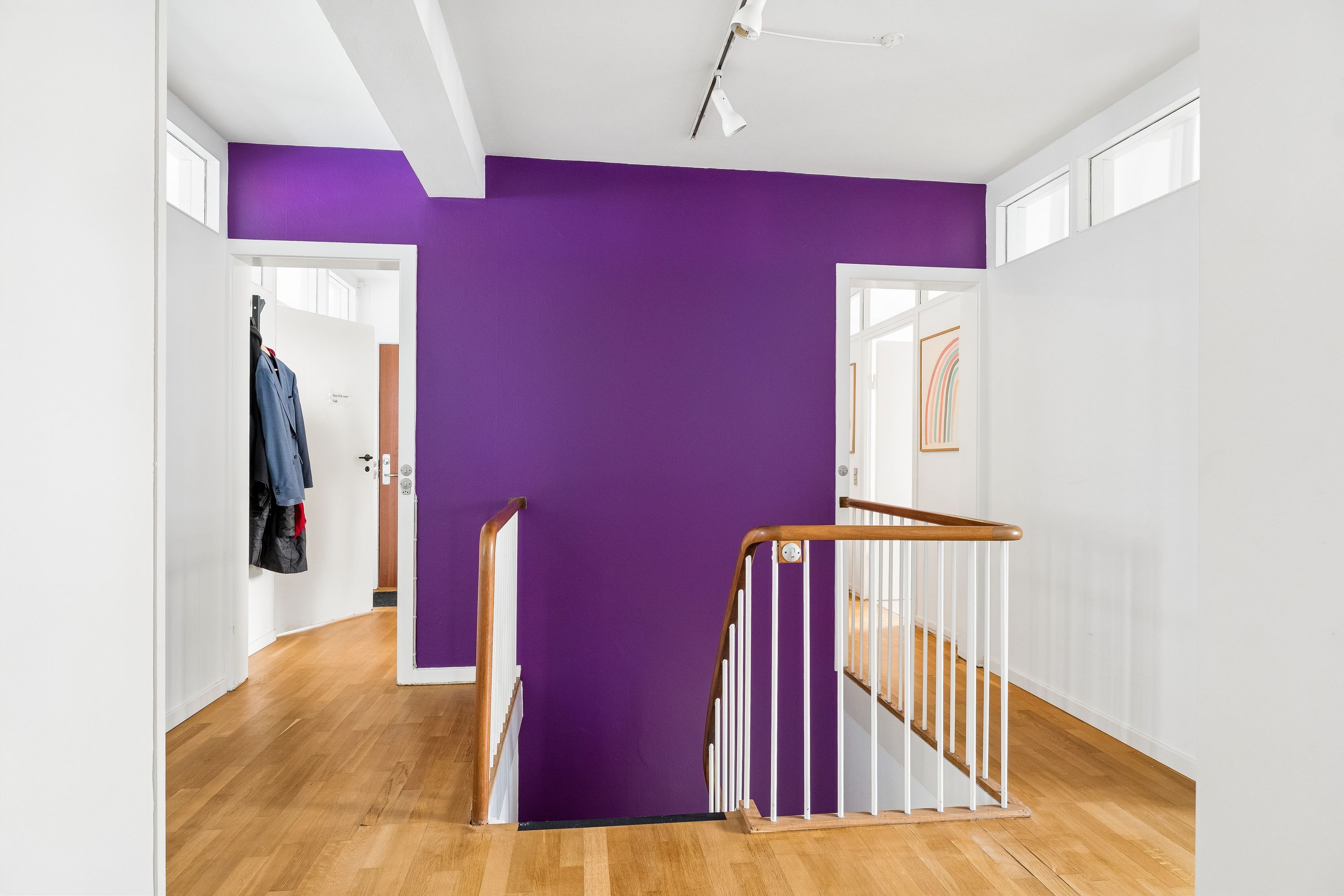 Hvidt og lyst erhvervslejemål med sort-hvidt trappedesign og en lysegrå og lyseblå væg i baggrunden