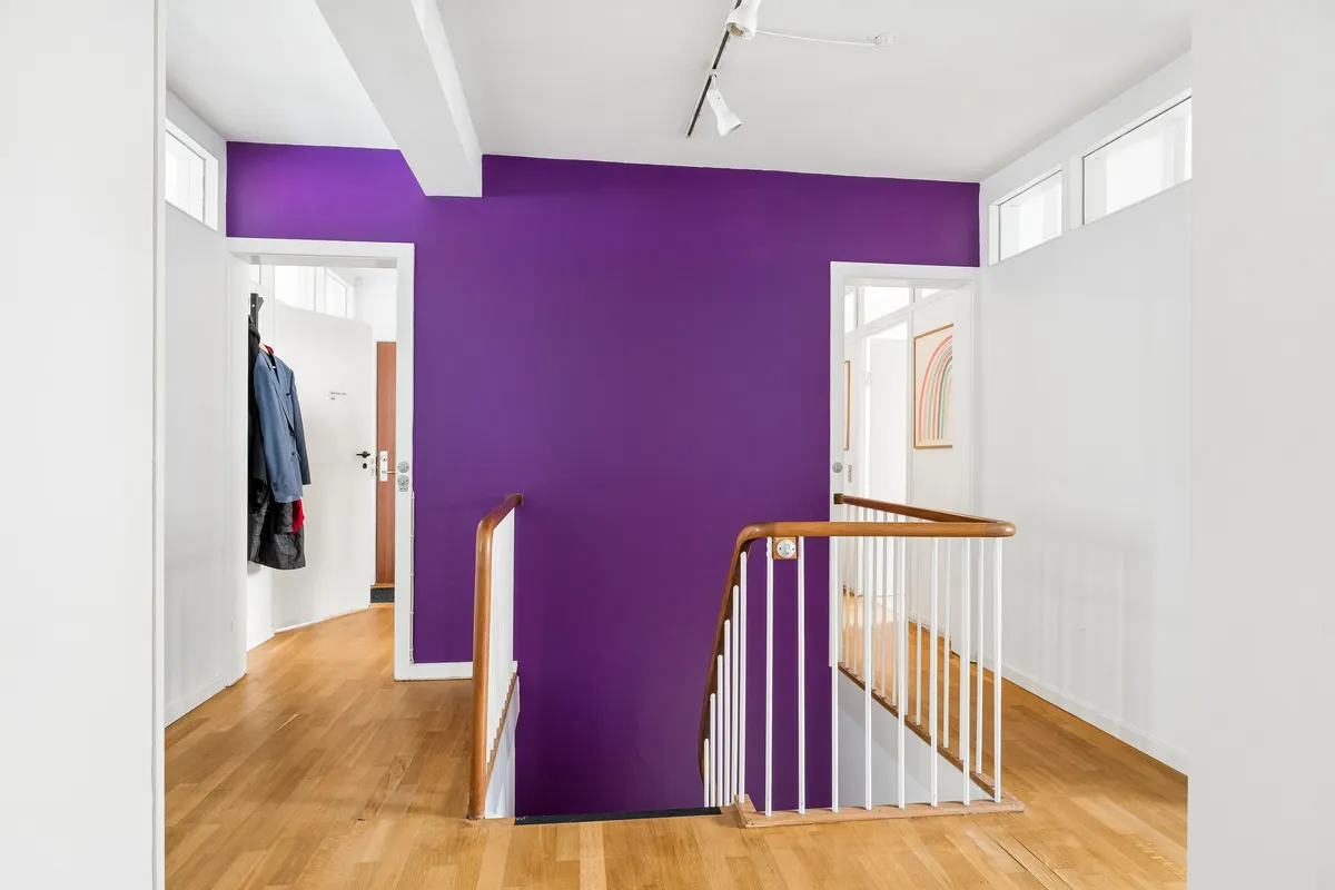 Hvidt og lyst erhvervslejemål med sort-hvidt trappedesign og en lysegrå og lyseblå væg i baggrunden