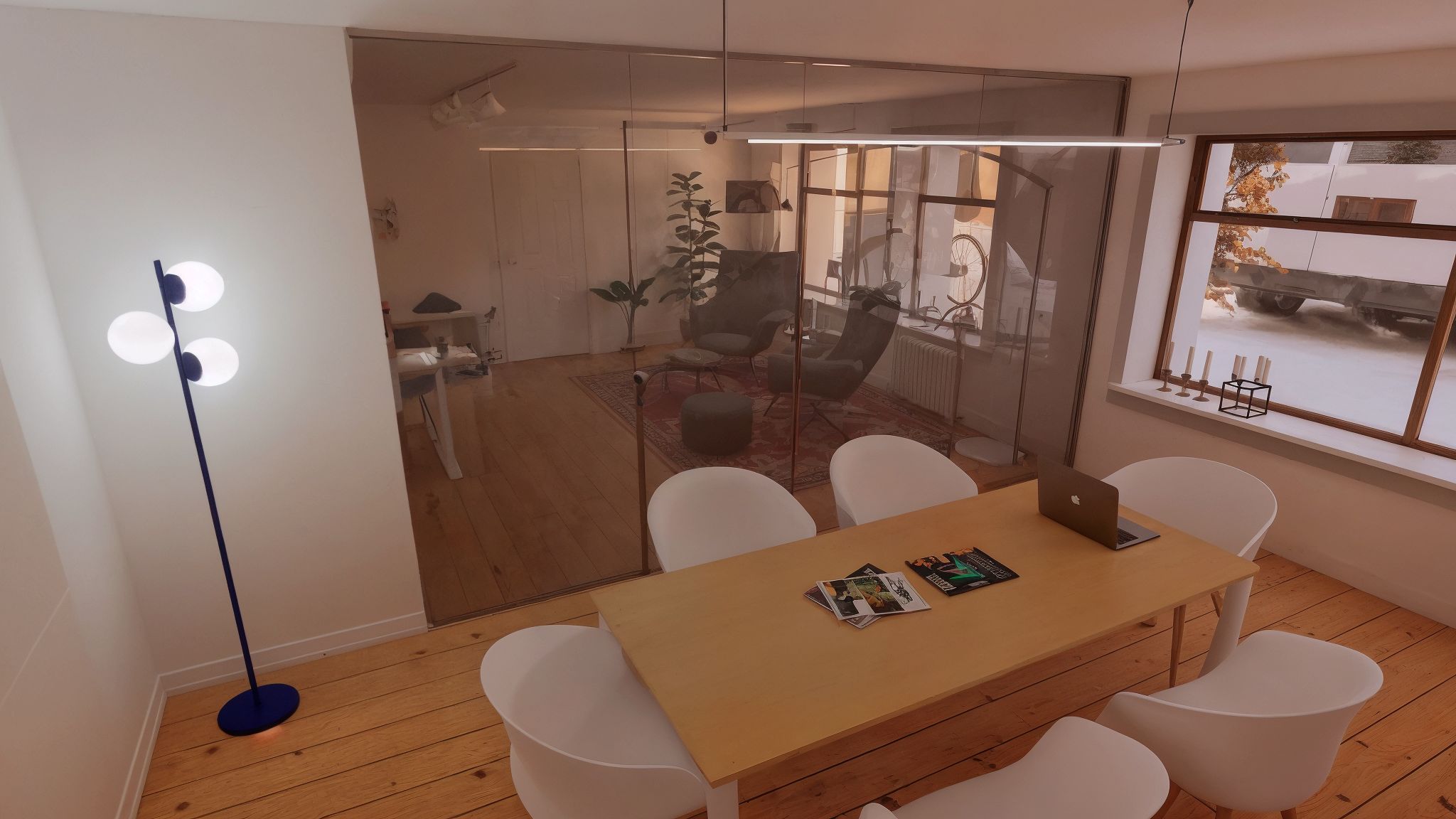 Kontor på 37 kvm med møbler og lysekroner, hvor der er plads til flere mennesker. Der er et trægulv, og det er let at se igennem glasvæggene.