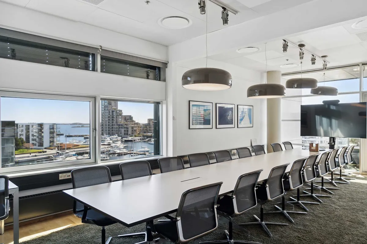 Store mødelokkal med udsigt til Øresund og havnen, moderne møbler og lyse loftslamper i en hvidt malet stue