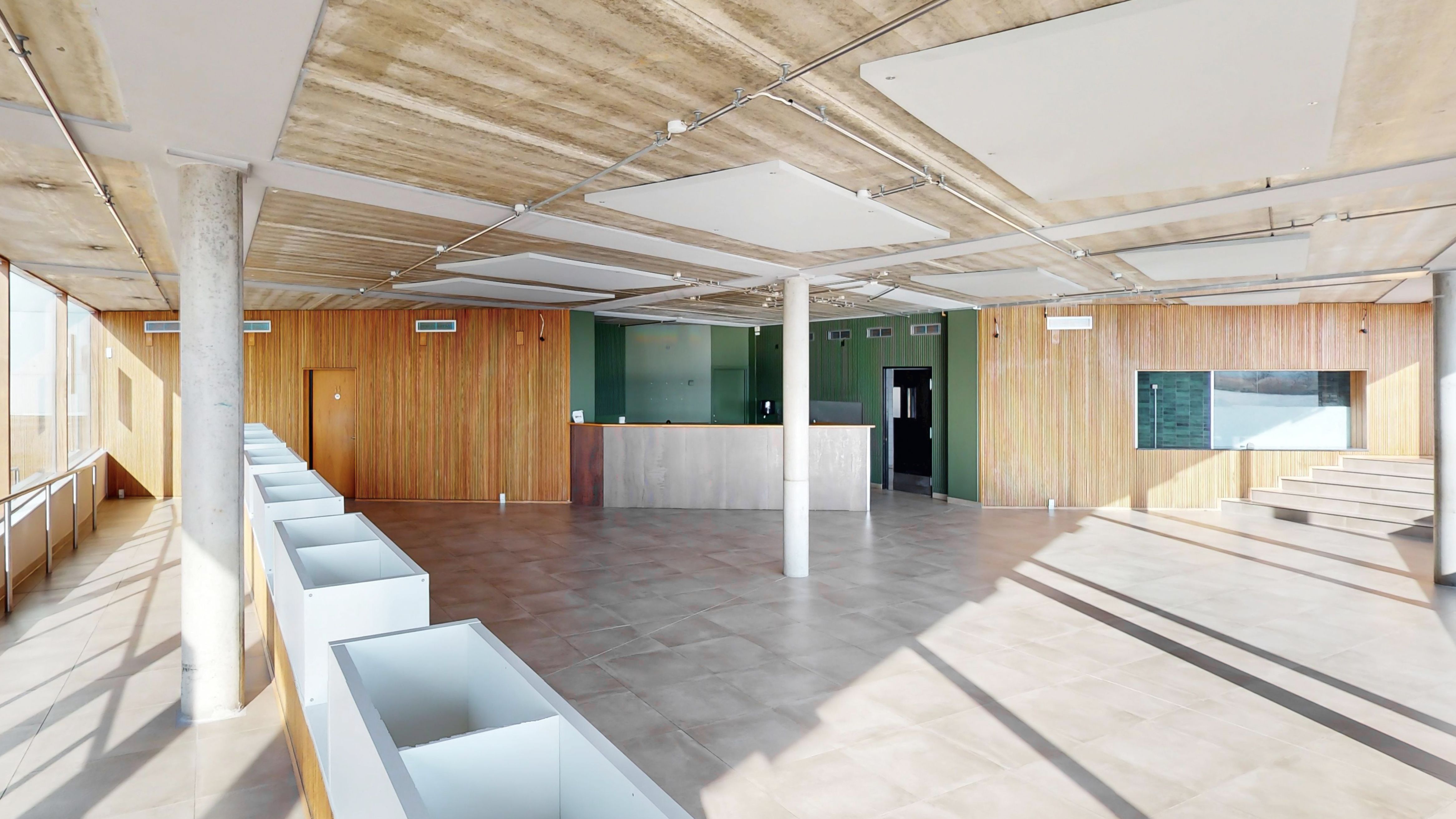 Indvendigt i lejemålet i Ørestad er der et åbent rum med lysegult gulv og hvide vægge samt loftspaneler