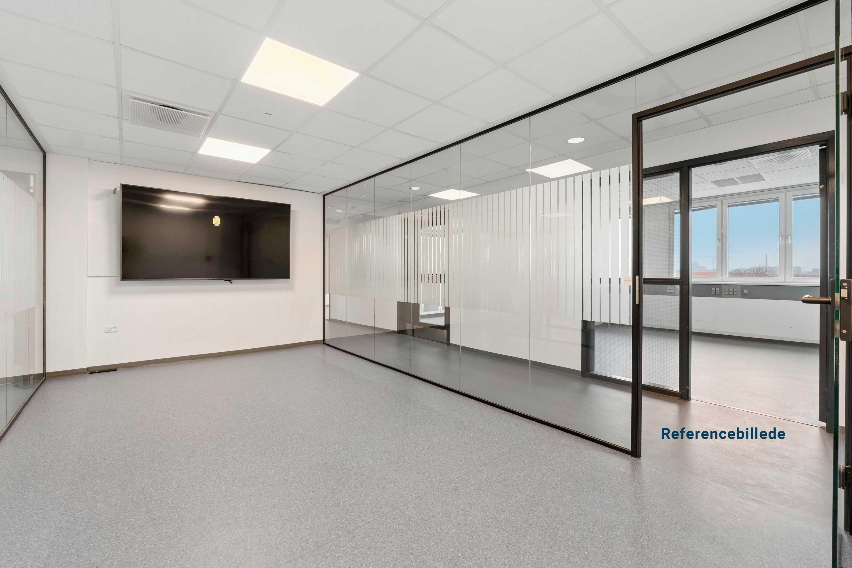 Lyst kontor med glasvægge og moderne møbler, et stort tv hænger på væggen og døre og vinduer er åbne