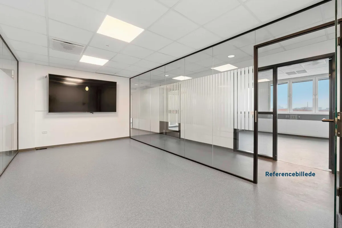 Lyst kontor med glasvægge og moderne møbler, et stort tv hænger på væggen og døre og vinduer er åbne
