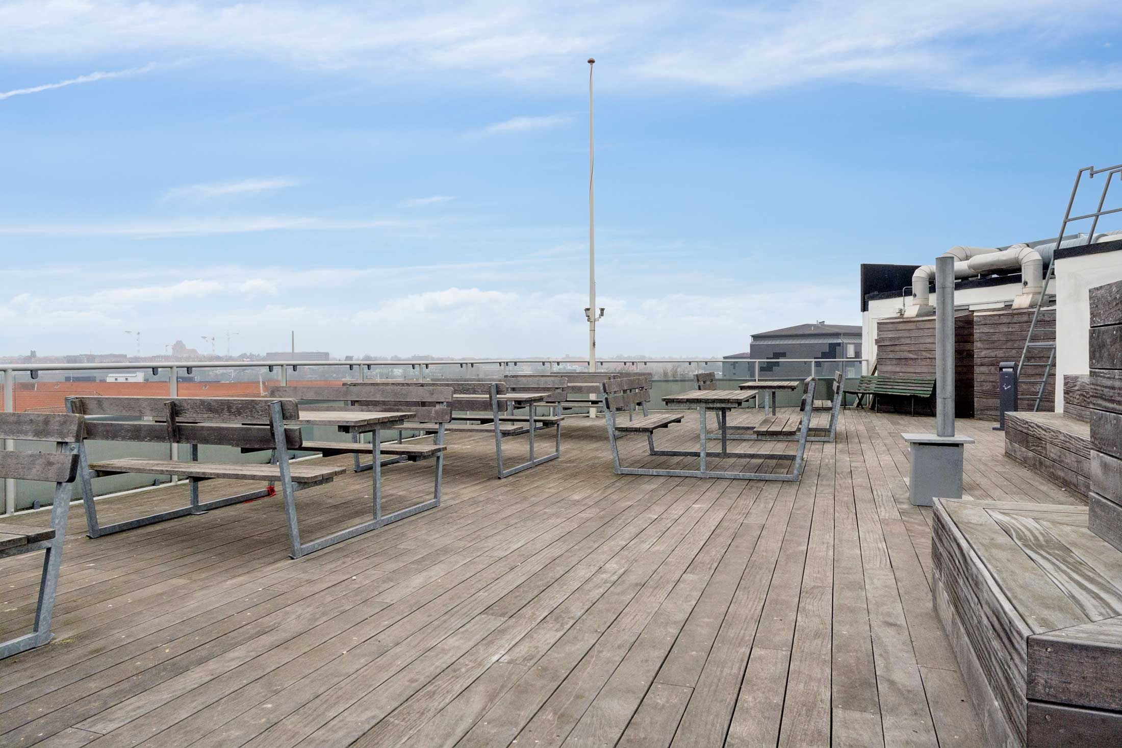 Lyst og nyt laboratorium med udendørs terrasse. Terrassen med udendørs møbler og spiseborde. Lyst og nyt kontor med udsigt til byen. Lyst kontor med nye møbler og moderne design.