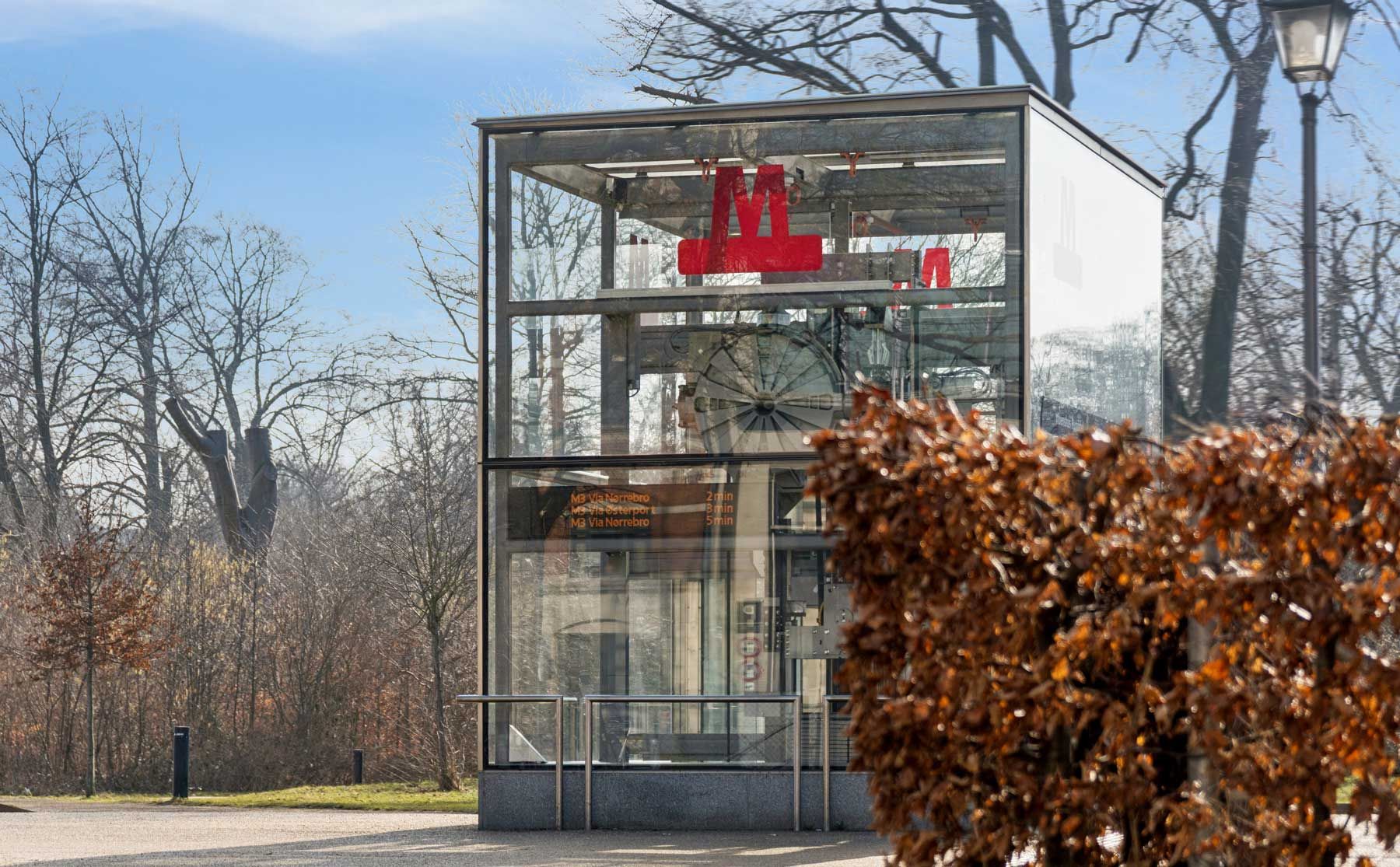 Lyst og nyistandsat laboratorie med kontor i København Ø. Lyst laboratorium med glasvægge og rødt M på væggen. Planter og træer bag laboratoriet