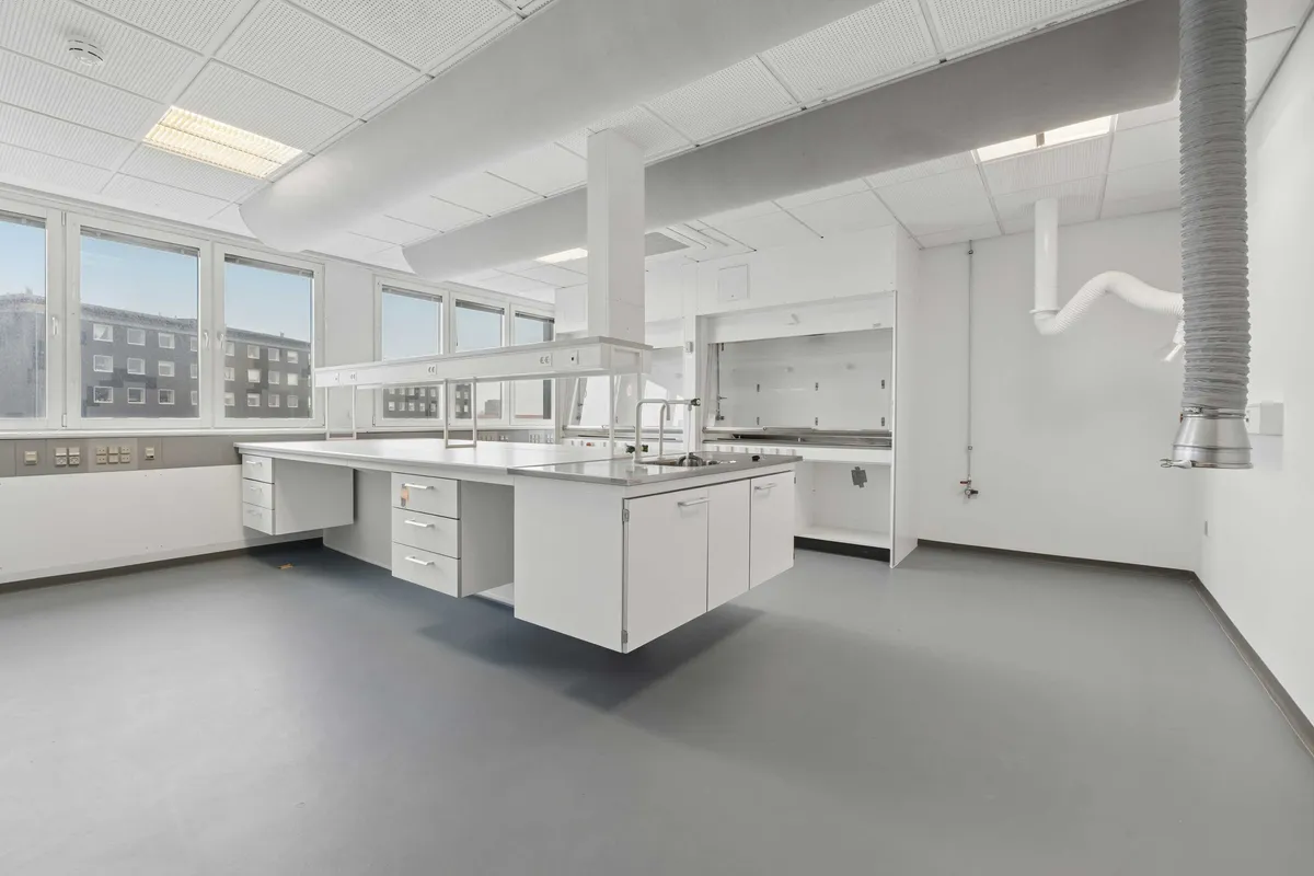 Lyst og moderne laboratorium med højt loft, ren gulv og store vinduer. Værelse med høj kvalitet og lysefarvede vægge.