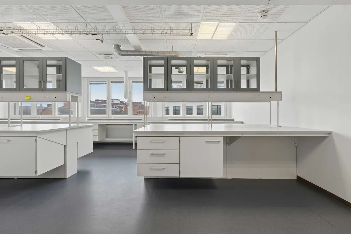 Lyst og moderne laboratorium med hvide kabinetter og gulve i København Ø. Laboratoriet har en industriel stil med hvide vægge og loft.