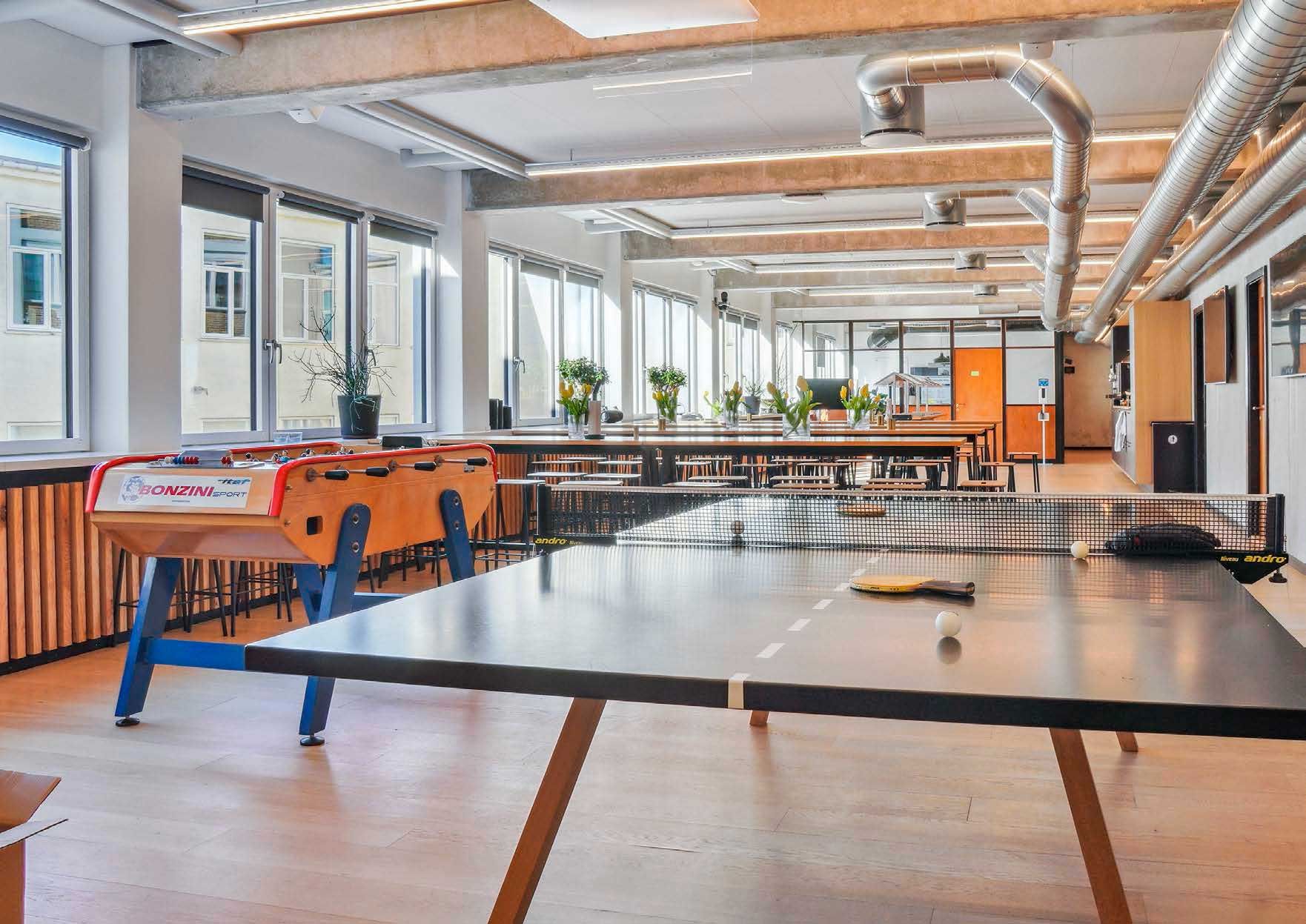 Kontorlejemål med pingpongbord, fodboldbord og plante i lyse kontorer med masser af vinduer og lyse lofter