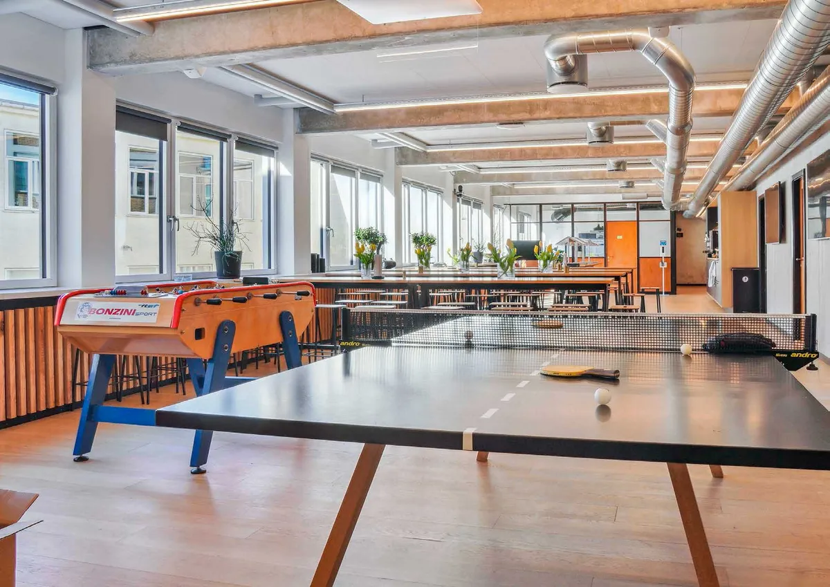 Kontorlejemål med pingpongbord, fodboldbord og plante i lyse kontorer med masser af vinduer og lyse lofter