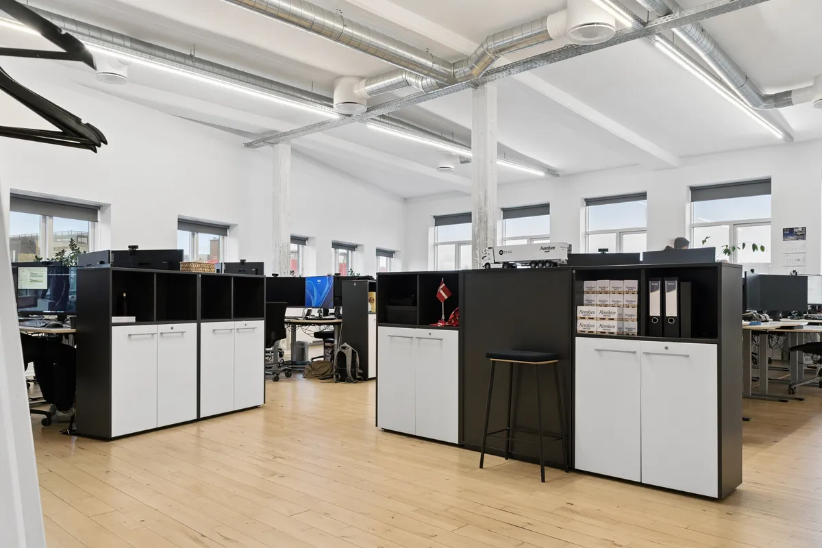 Kontorlokaler med højt til loftet og lyse vinduer i røgkammeret på Laplandsgade 4A i København S. Fladt loft med hvide vægge og lyse trægulve. Moderne og funktionelle møbler samt teknologiske faciliteter.