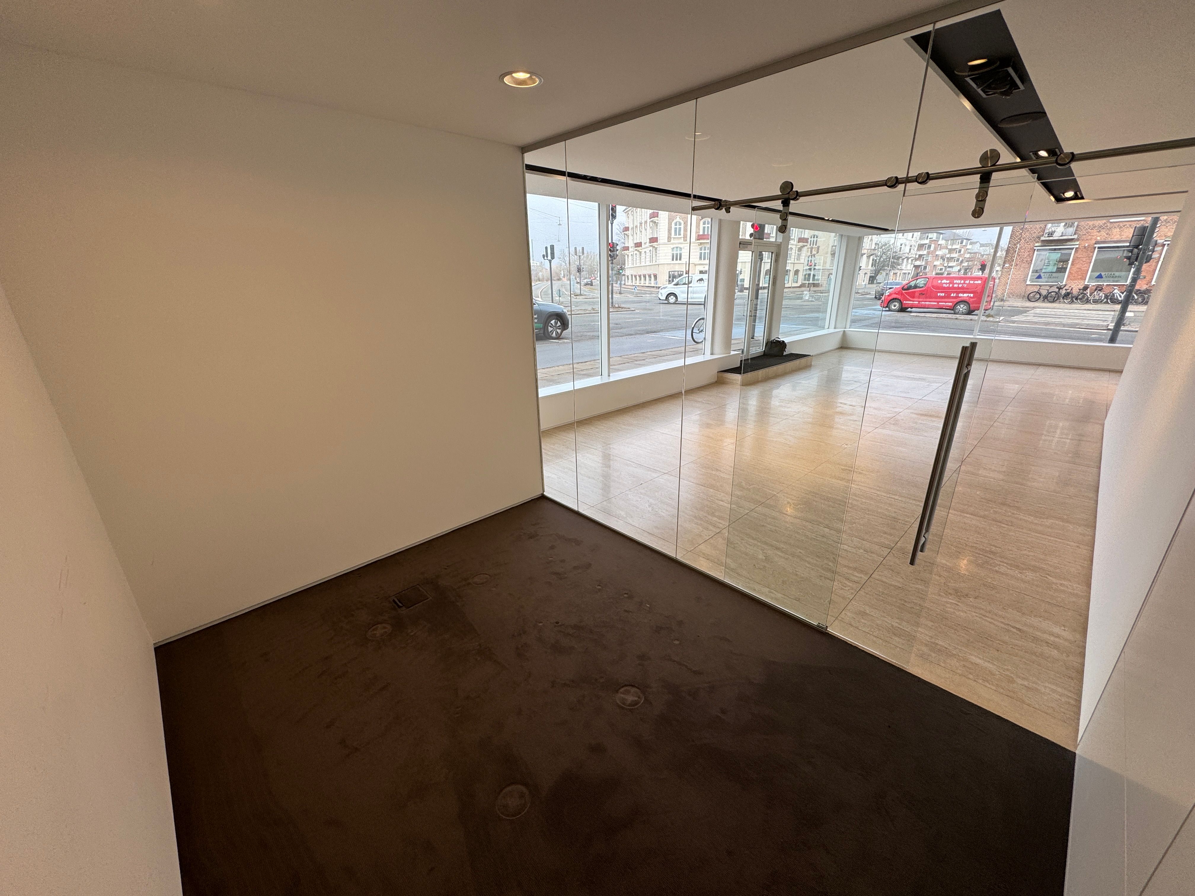 København Øs showroom med store glasvægge, gulvbelægning og indvendige hjørner i lyse farver udsat til leje