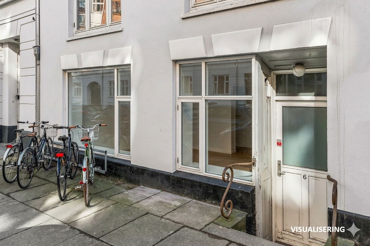 Butik til salg på Marstalsgade 6 med fire parkerede cykler udenfor og indgangsdør i træ med nummer 6 og lys.