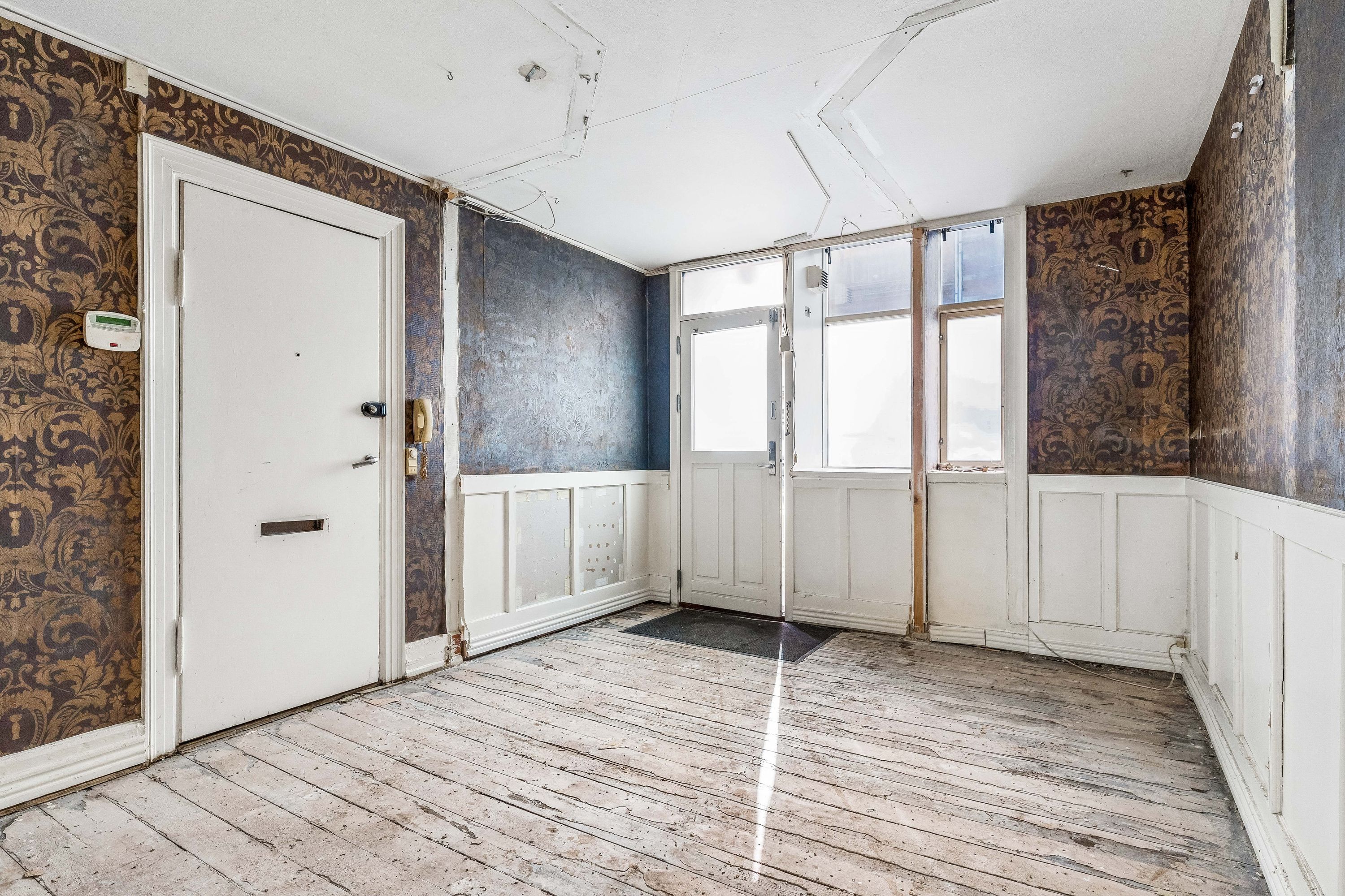 Tom lejlighed med lyse stueetagen og køkken. Det gamle gulv og de møblerede vinduer.