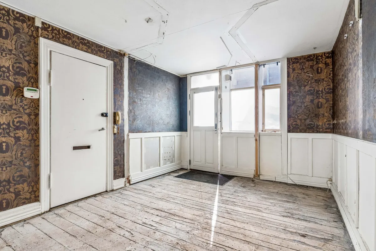 Tom lejlighed med lyse stueetagen og køkken. Det gamle gulv og de møblerede vinduer.