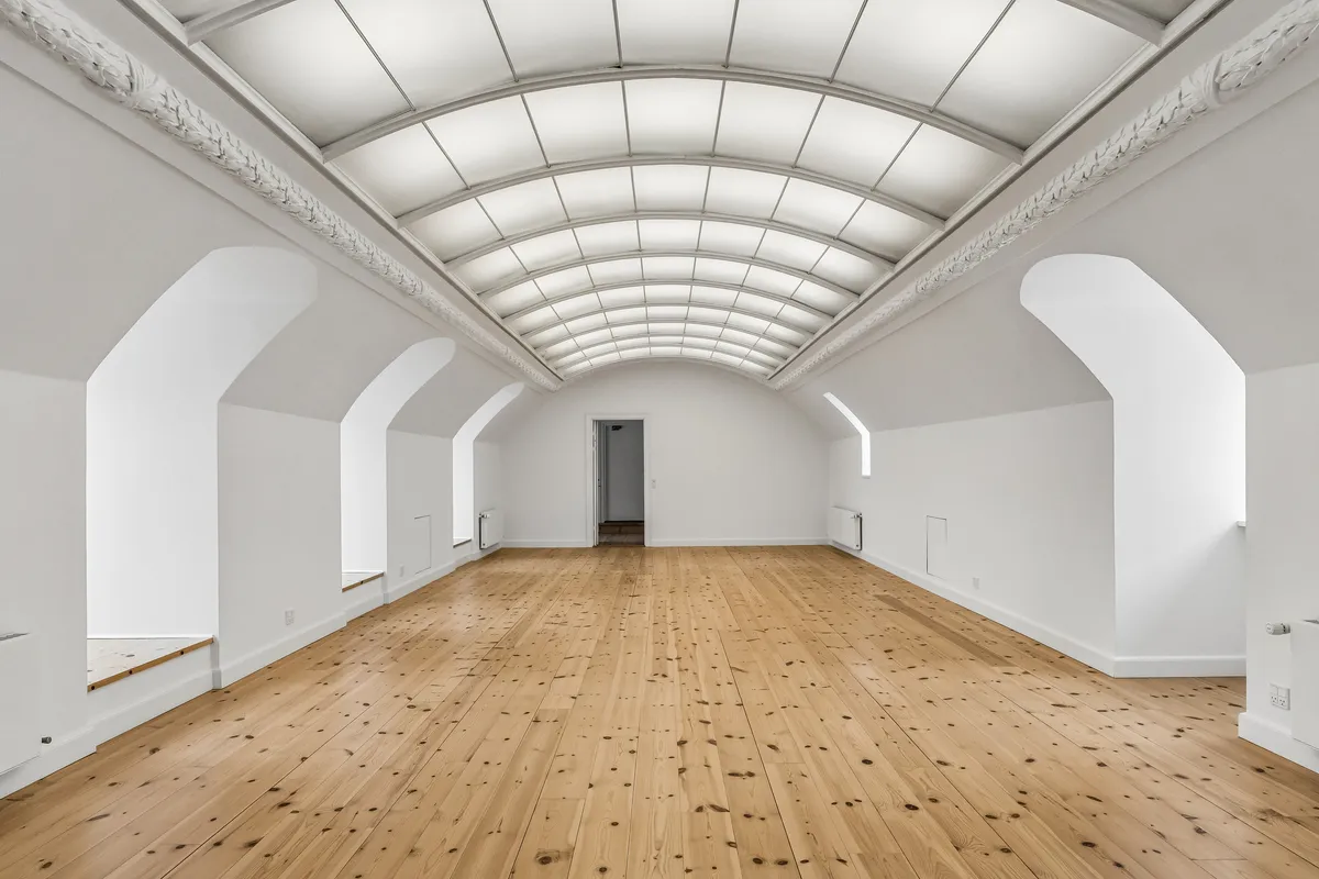 Luksuriøs og moderne kontorlokale med lyse lofter og trægulve, som er perfekt til møder og samarbejde i et sømløst design