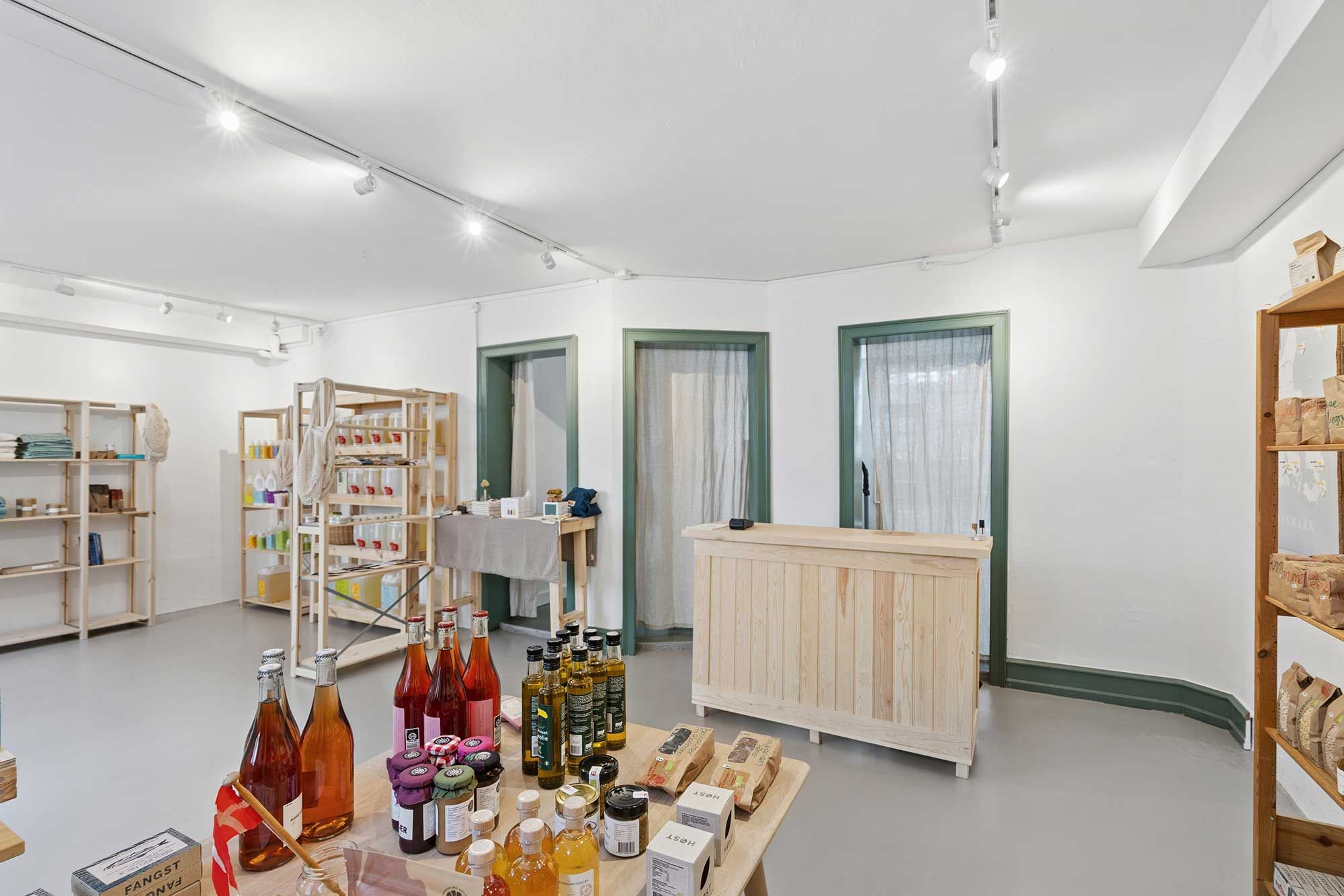 Butikslejemål med krydrede og søde produkter og et træskab med flere krydderier og syltetøj