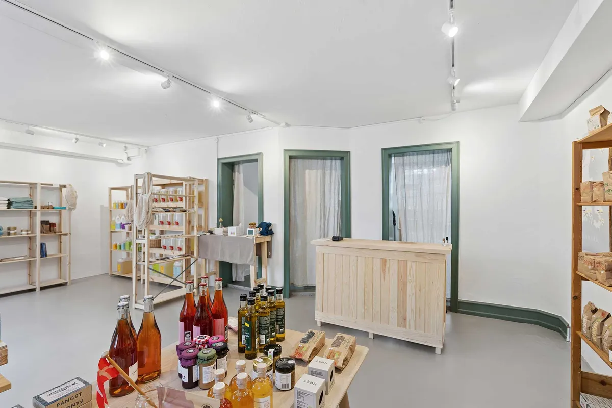 Butikslejemål med krydrede og søde produkter og et træskab med flere krydderier og syltetøj