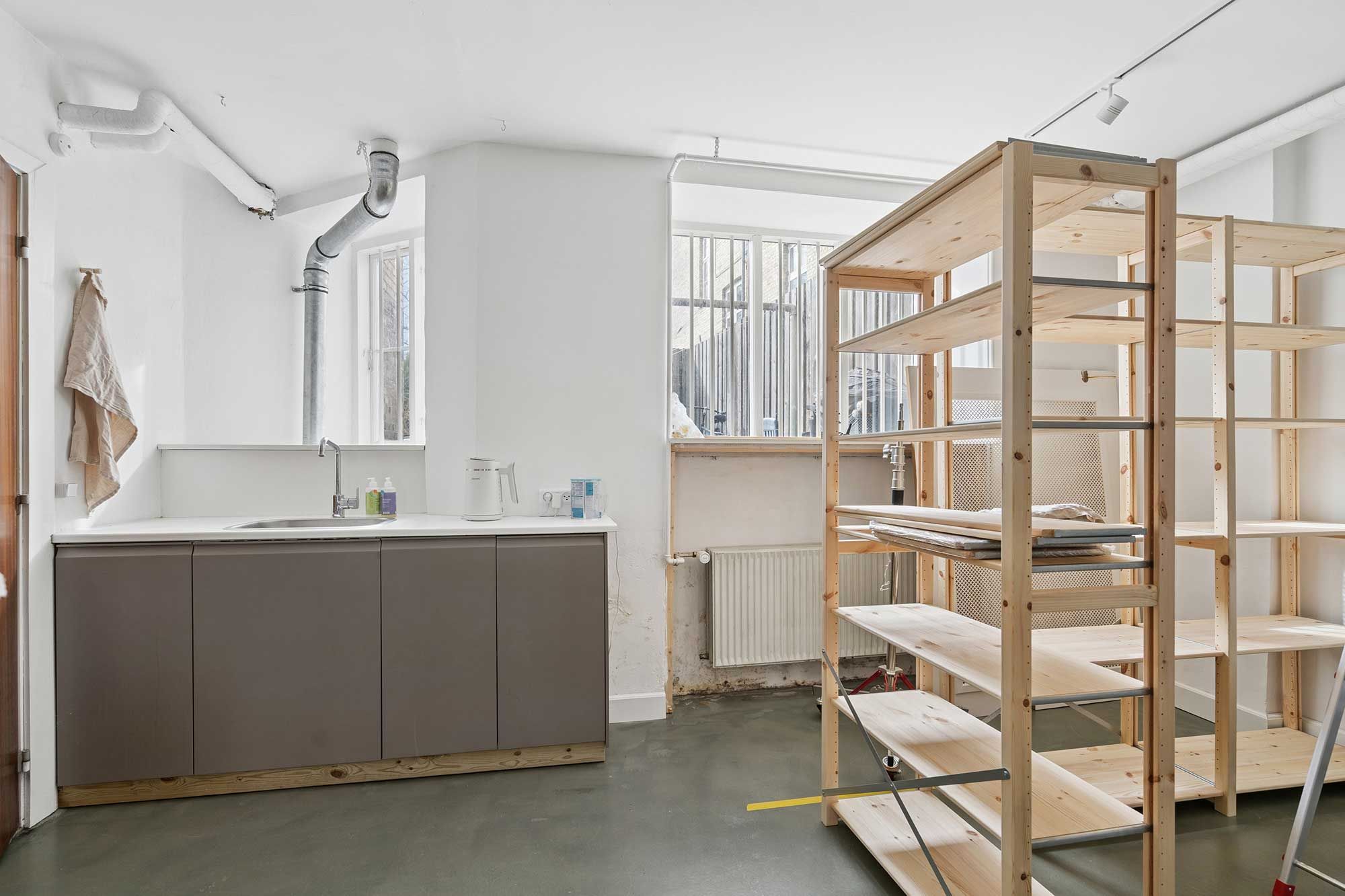 Lejlighed med to store værelsesrum med højloft og massivt gulv samt et køkken med hætte og lysekroner