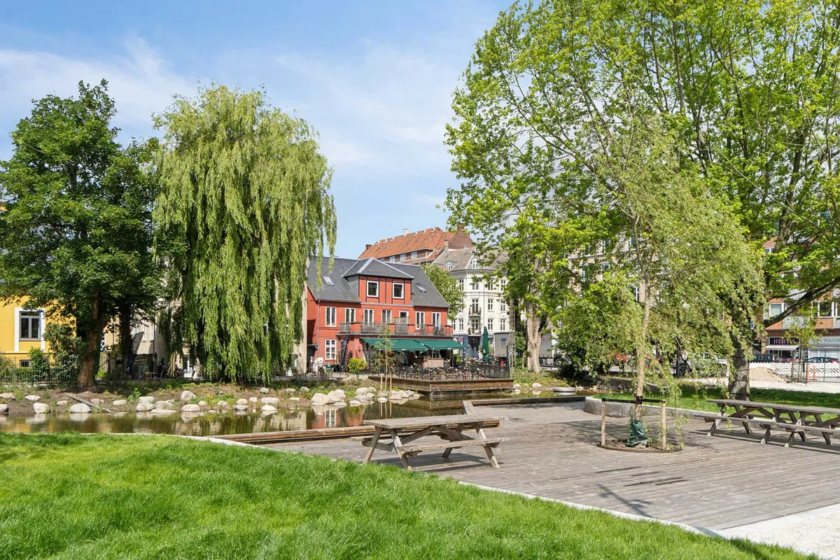 Frederiksberg Have med fredede træer, pavilloner, restaurant og park med vand og sten. Lejemål i rød bygning med balkon og grønne facader