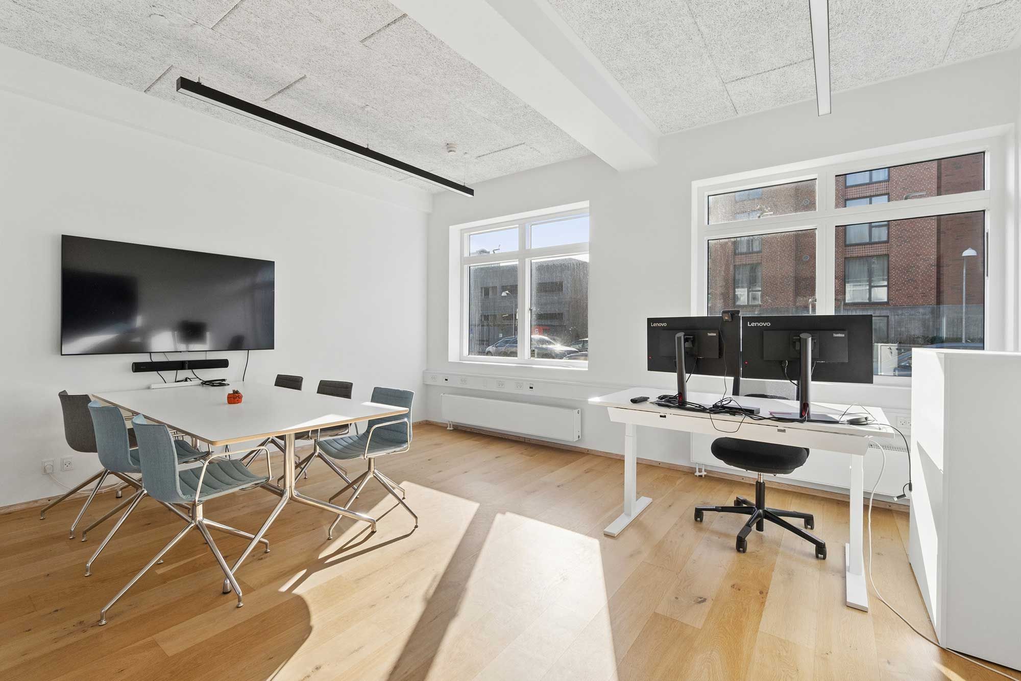 Kontorlokaler med højt til loftet og moderne møbler og teknologi til møder og konferencer i en stilfuld indretning