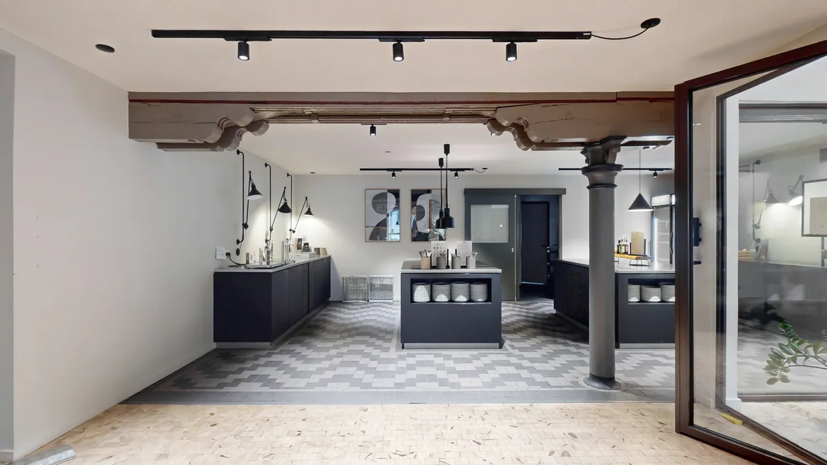 Kontorlokaler med store vinduer og lyse loftsrum med loftsbjælke og lysekroner. Moderne loftsrum med lyse loftsbjælke og lysekroner i loftet.