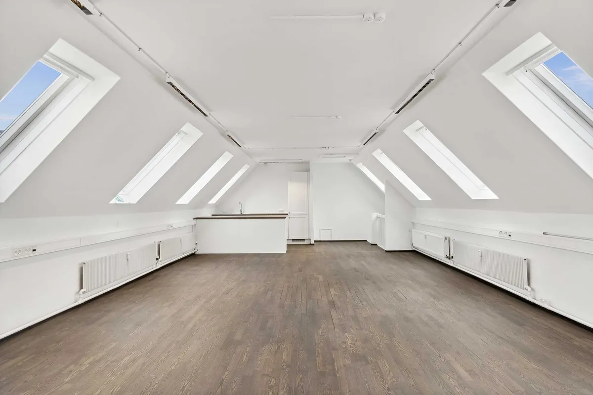 Nyrenoverede kontorlokaler med højloft og lyse loftsvindue. Nyrenoverede kontorlokaler med moderne design og trægulv