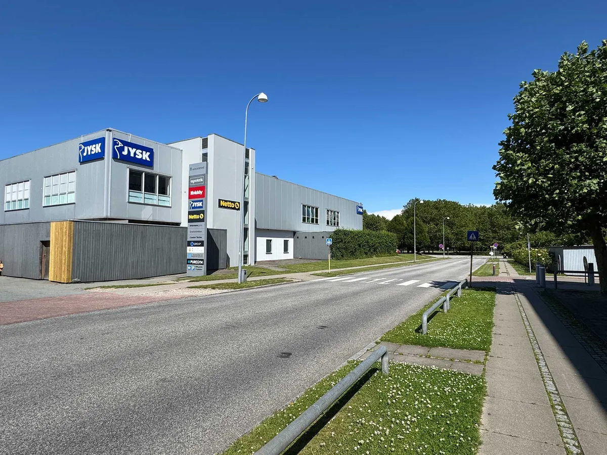 Lejemål med højt til loftet og store vinduer på Nygårds Plads 21, Brøndby. Forretningsformål med 5 behandlerrum og tekøkken. Adgangsvej med græsplæne og træer.