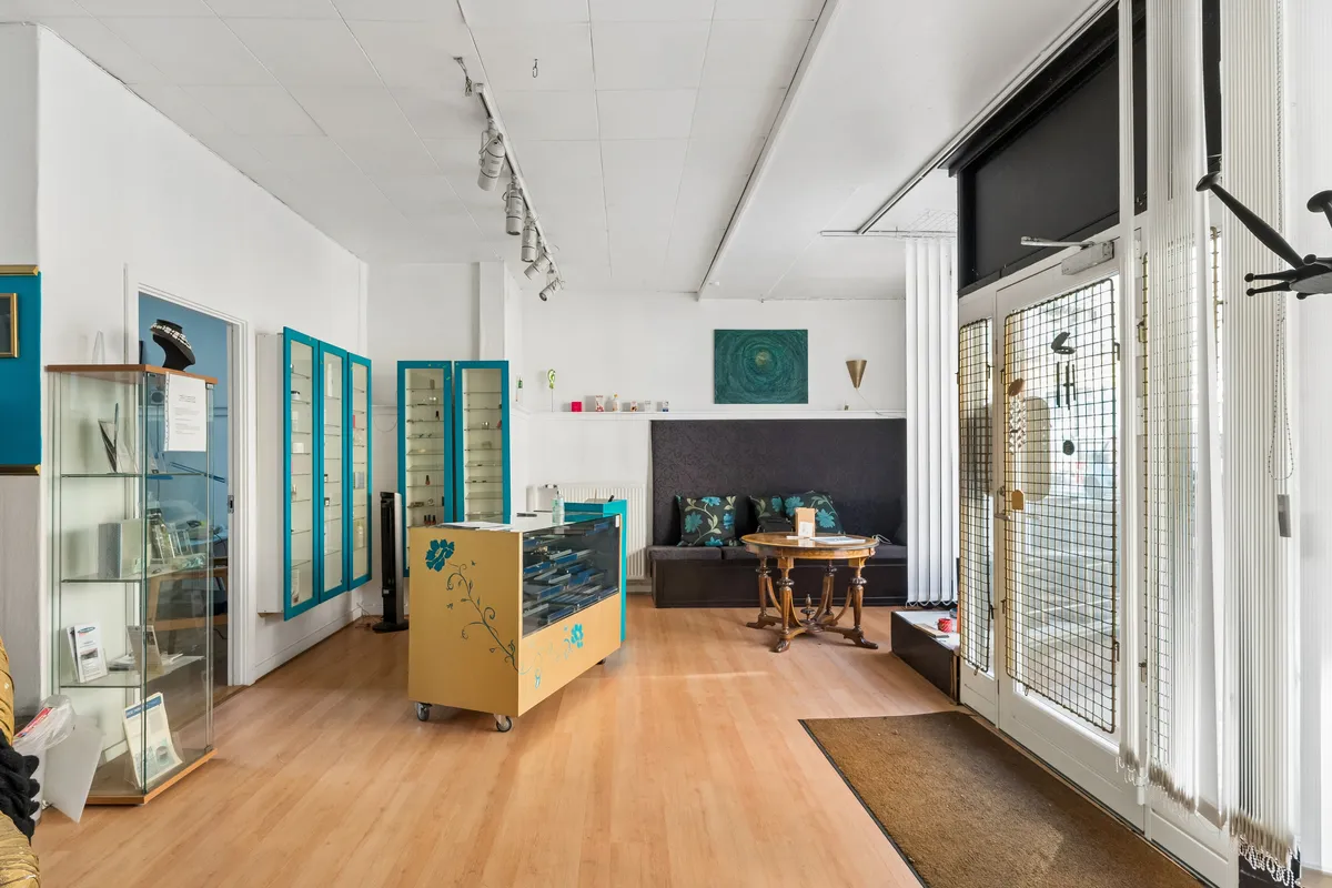 et smukt møbleret og moderne showroom med lyse lofter, gulve og vægge, hvor der er udskærne glasvitriner og et smukt sølv sølvskrue.