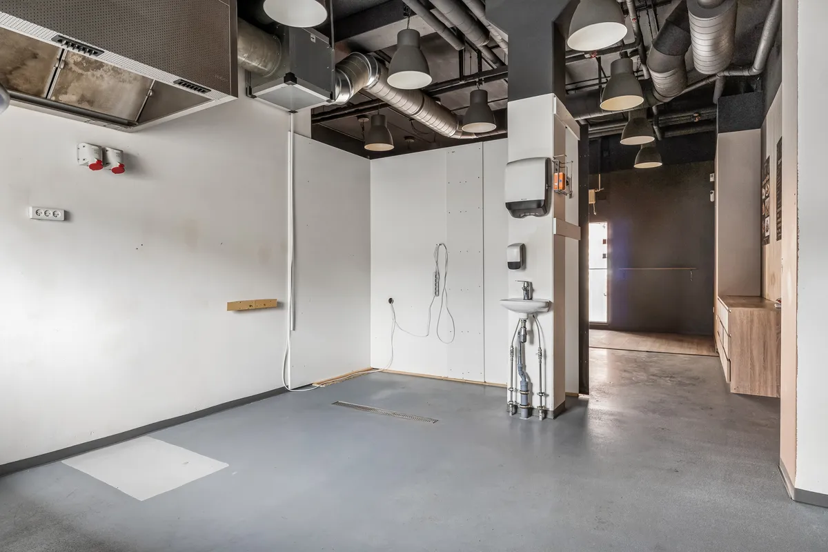 Et tomt badeværelse med moderne design. Væggene er hvide, og der er en hængende håndklædetørrer og et hvidt vask. Der er også et gulv med en hvid plade.