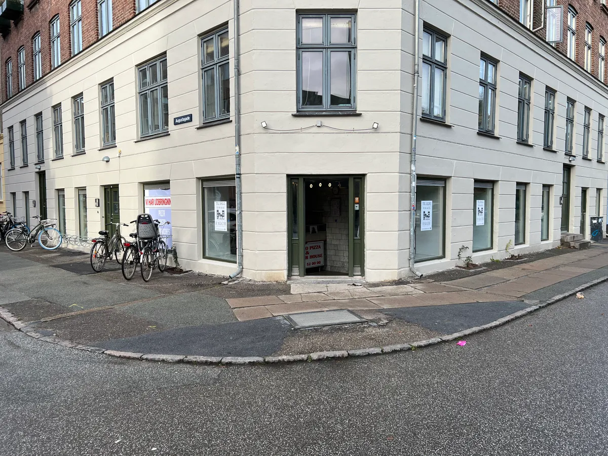 Pizza og R House har åbent for forretningslivet på Kirkegårdsvej 38. Hjørnelokalet har udsigt til gaden og er let tilgængeligt for gående og cyklister.