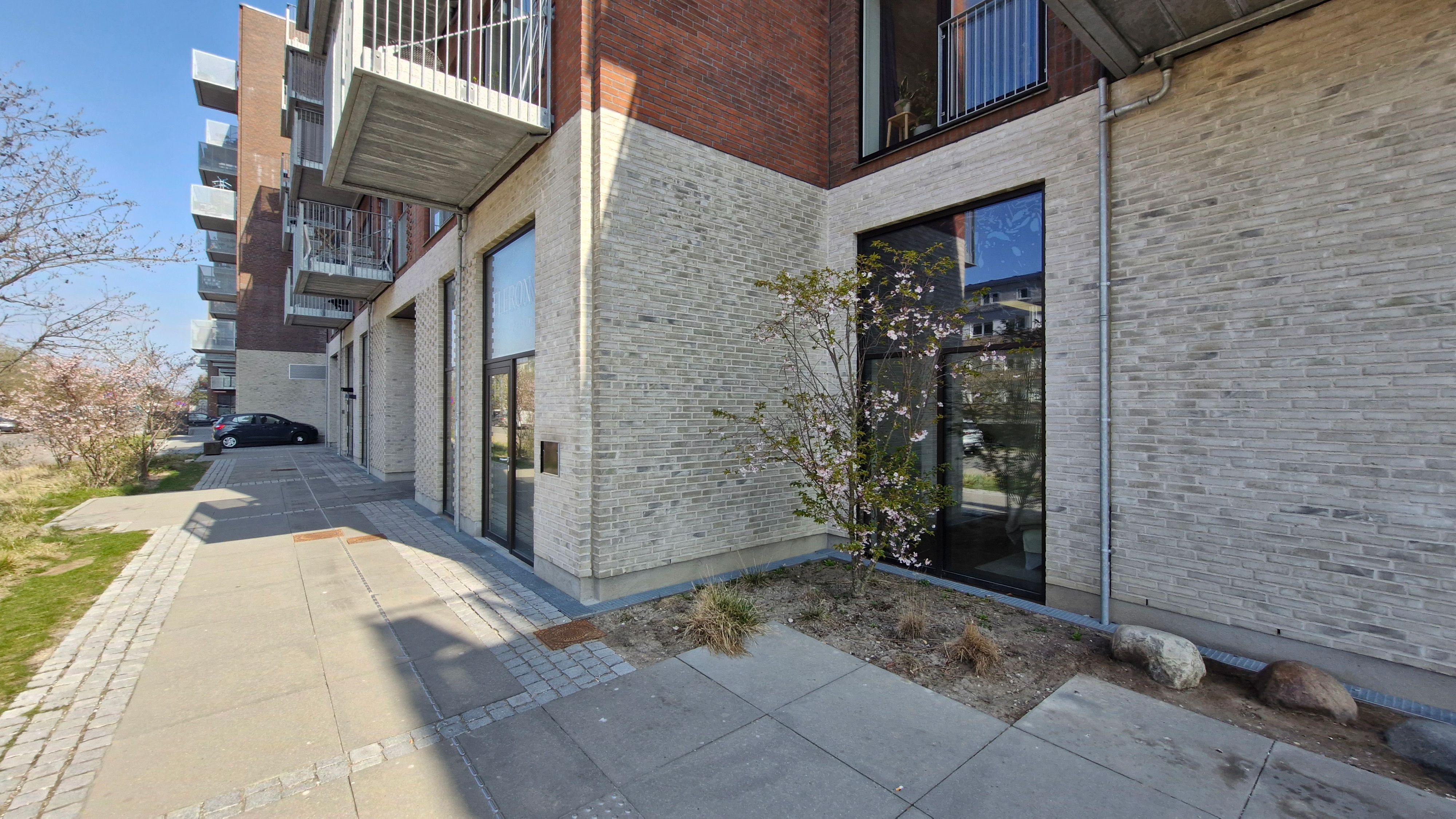 Kontorlejlighed med moderne facade, store glasvinduer, terrasse og grønne planter på Næsbyvej i Rødovre. Bygningen har lyse værelser og er velegnet til små virksomheder.