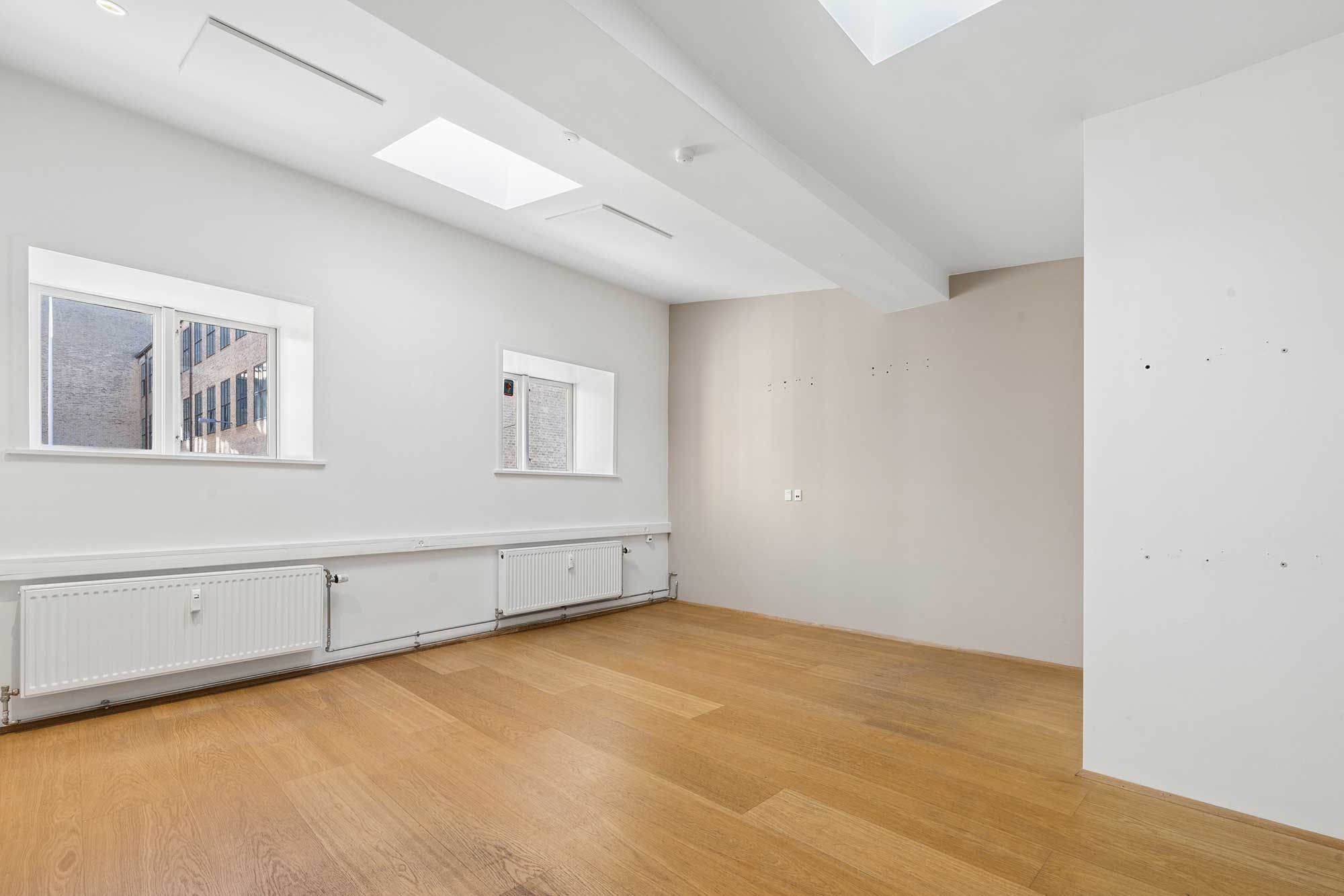 Hyggeligt og soligt kontorlokal i Sølvgården i Indre By med to vinduer og lyse lofter