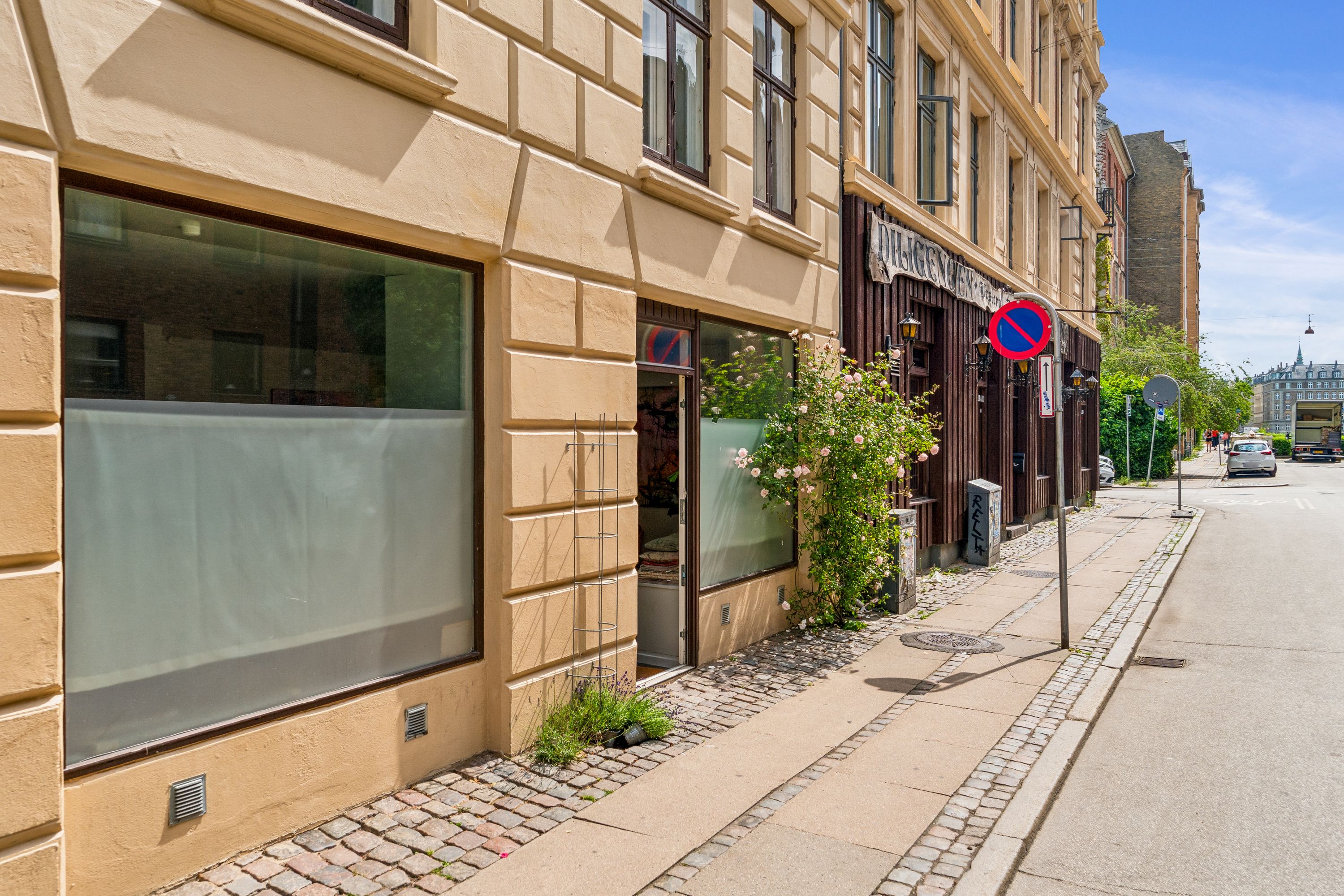 Øverste etage i et stort hus med en plante og glasruder på Korsgade i København