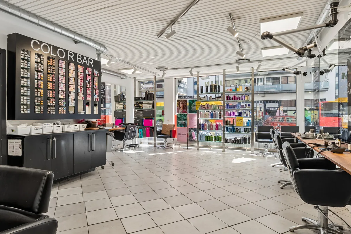 Køb denne frisørsalon på H.C. Ørsteds Vej 1B med lyse lofter og gulv. Sorte stole, røde barberskærere og farverige vægge. Butikken er forberedt til ny brug.