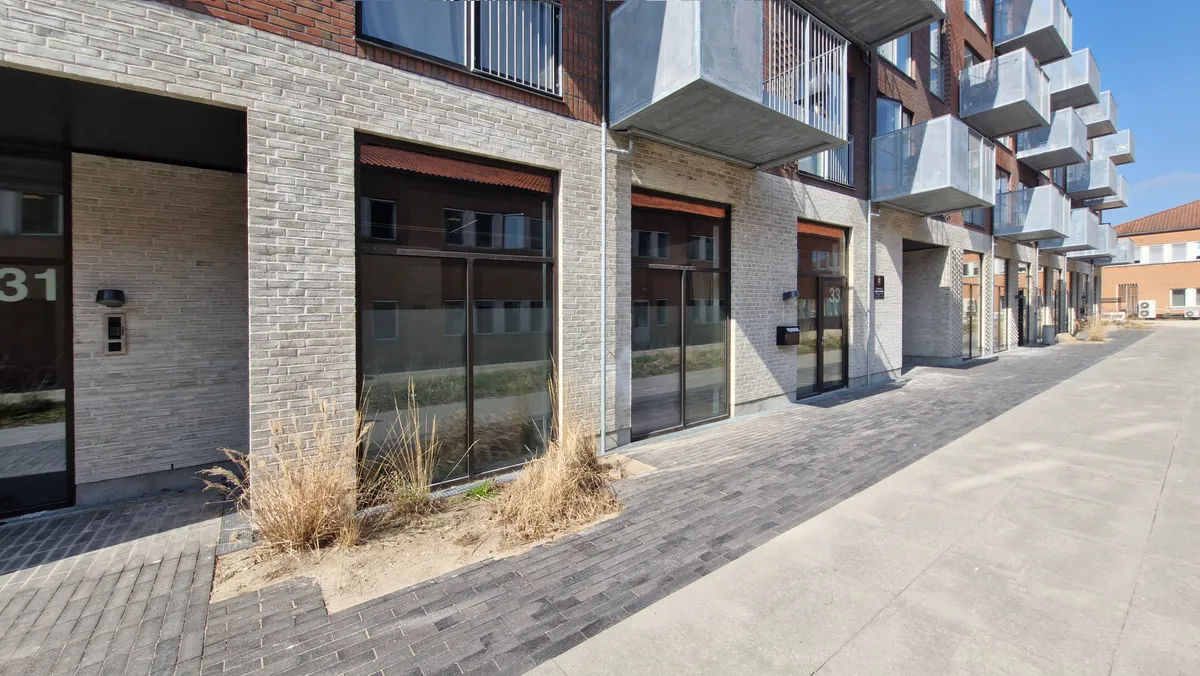 Moderne kontorbygning med glasvinduer og trapper til leje i Rødovre. Knægt og terrasser. Adresse 33 og nummerplade.