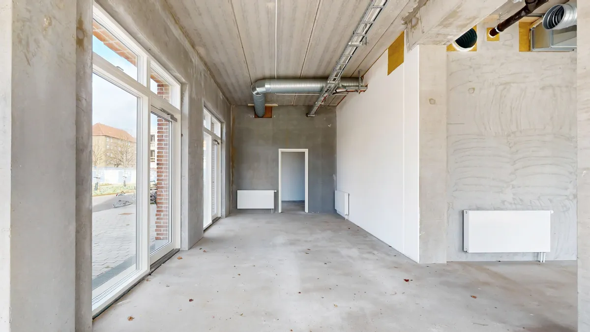 En stor lejemål med hjørneposition og glasruder, to radiatorer og luftkanaler samt en stor vinduesåbning