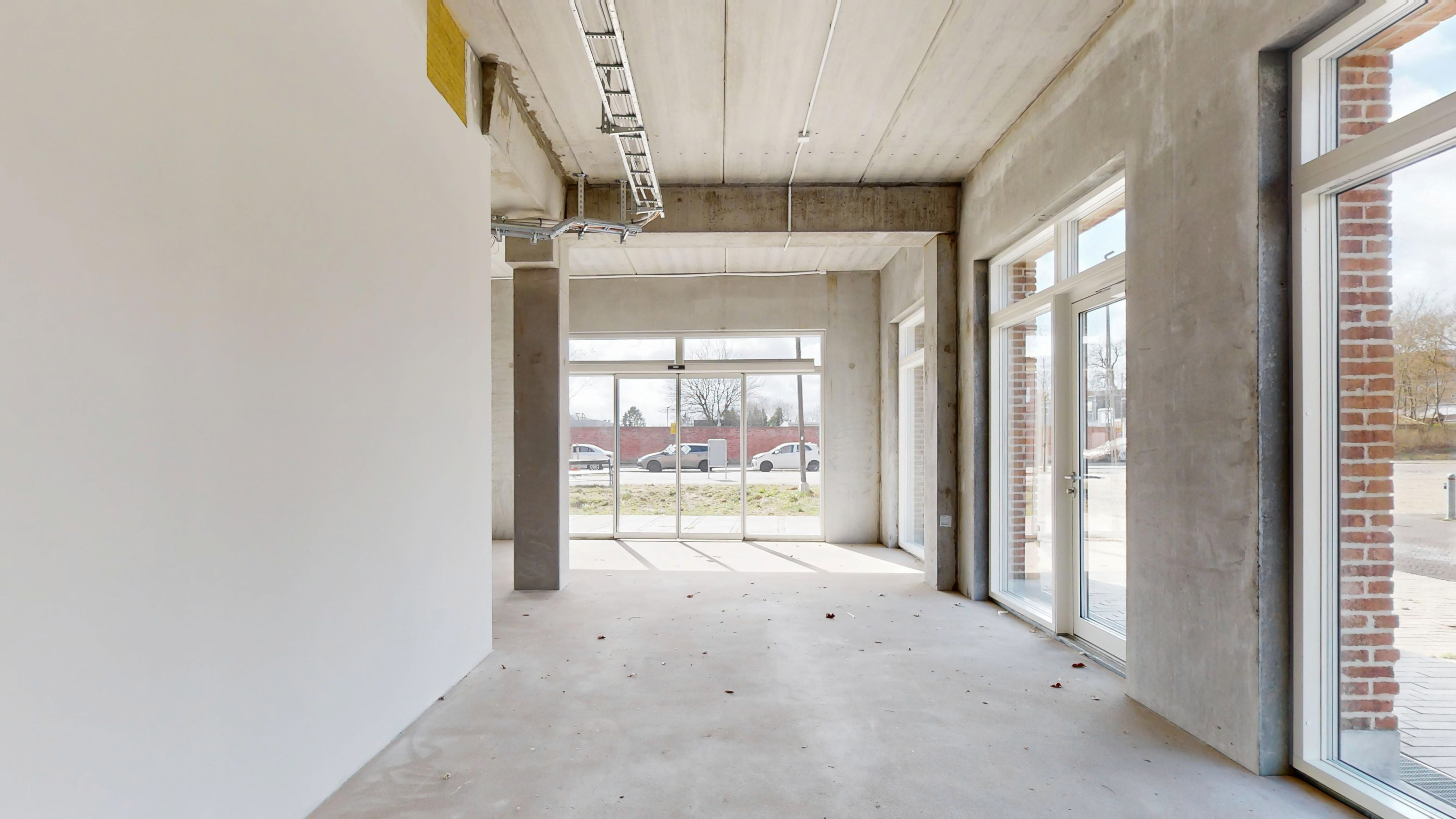 Nybygget erhvervslejemål i Sydhavn. Lejlighed med store glasruder og åben indgang. Lejemålet er ubeboet med hvidt loft og vægge.