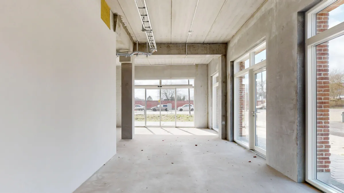 Nybygget erhvervslejemål i Sydhavn. Lejlighed med store glasruder og åben indgang. Lejemålet er ubeboet med hvidt loft og vægge.