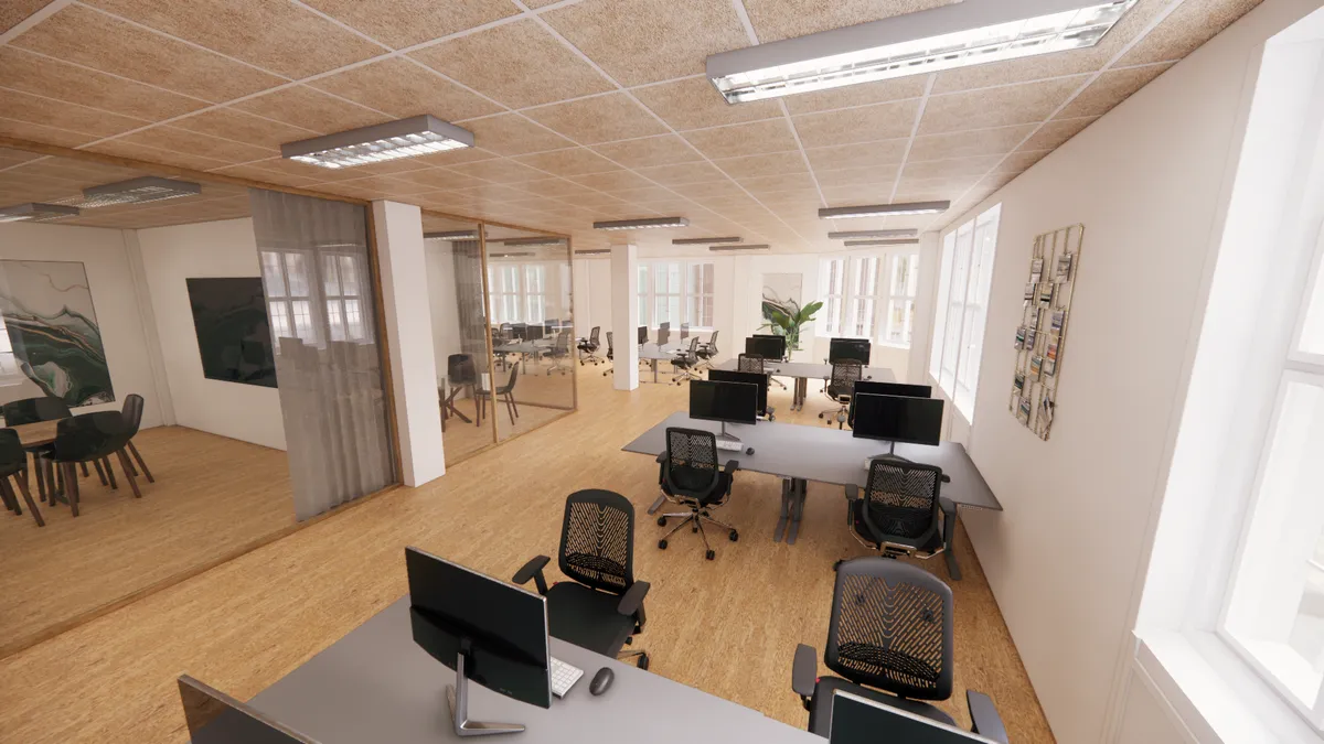 Kontorrum med højt loft, moderne møbler og vinduer, der giver udsigt til Kongens Have. Det er en del af Møntergården, en historisk bygning fra 1916.