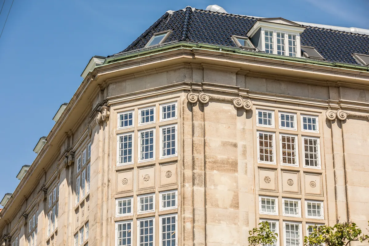 Et elegant bygning med mange vinduer, smukt dekoreret facade og slanke søjler, der vender mod Kongens Have. Bygningen er opført i 1916 og ligger på Sjæleboderne 2.