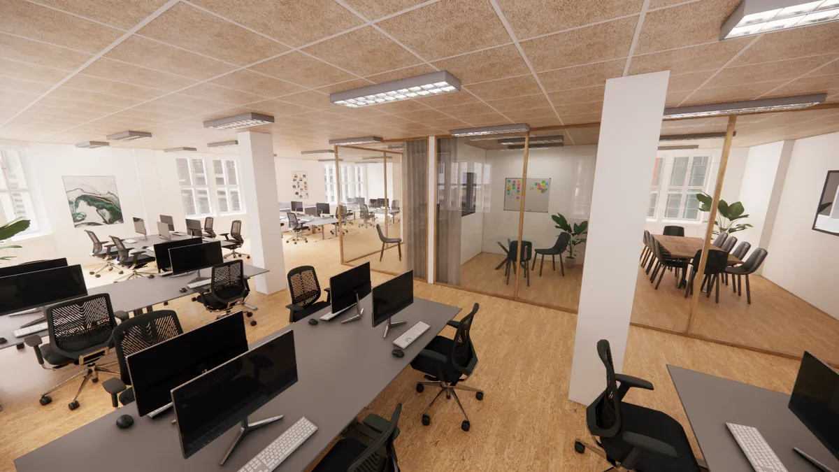 et moderne kontor med lyse vægge og trægulve. Der er et lille mødelokale med skrivebord og stole samt et større mødelokale med borde og stole.