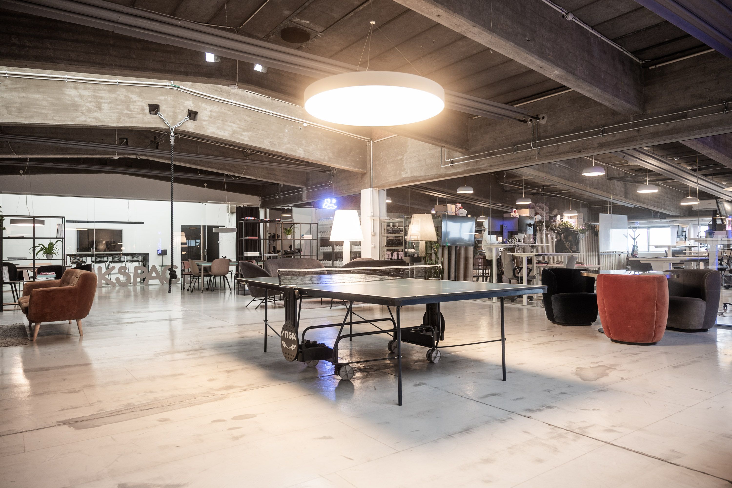 Kontor med pingpongbord, møbler, tv og lyskabler på loftet, for at skabe et hyggeligt arbejdsmiljø i kontorlokaler