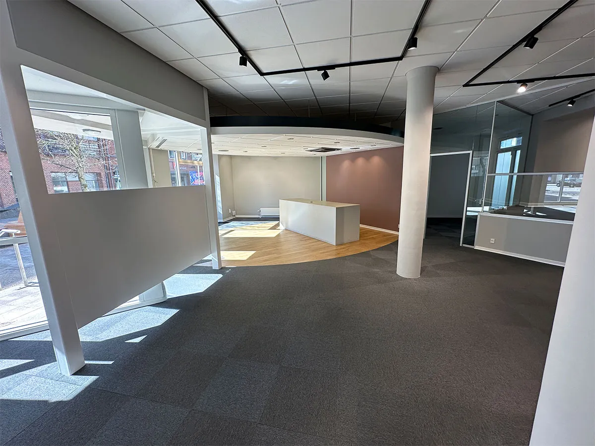 Erhvervslokale med høj synlighed i Hjørring. Store vinduer og lyse loftsarealer skaber et vellyst. Moderne gulvbelægning og minimalistisk møbleret.