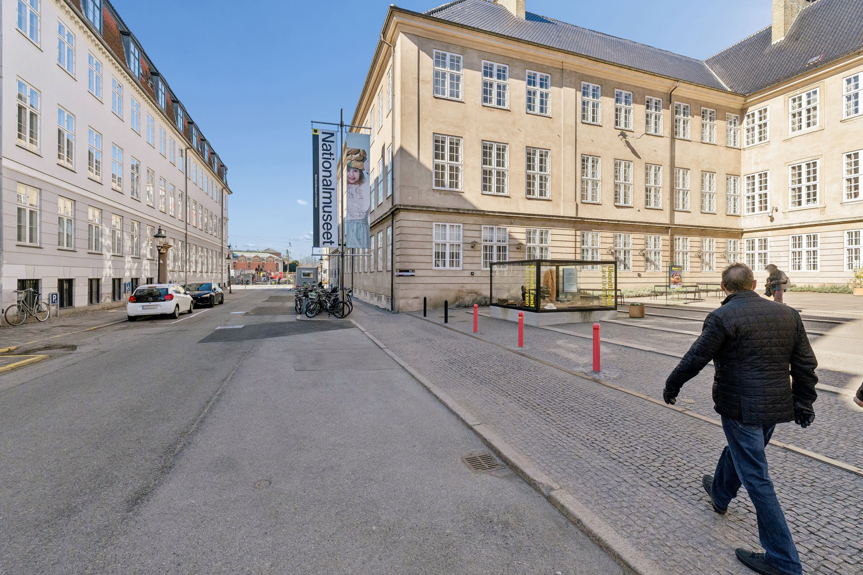 Kontor til leje på Ny Vestergade med søjler og vinduer. En mand går forbi og cykler er parkeret.