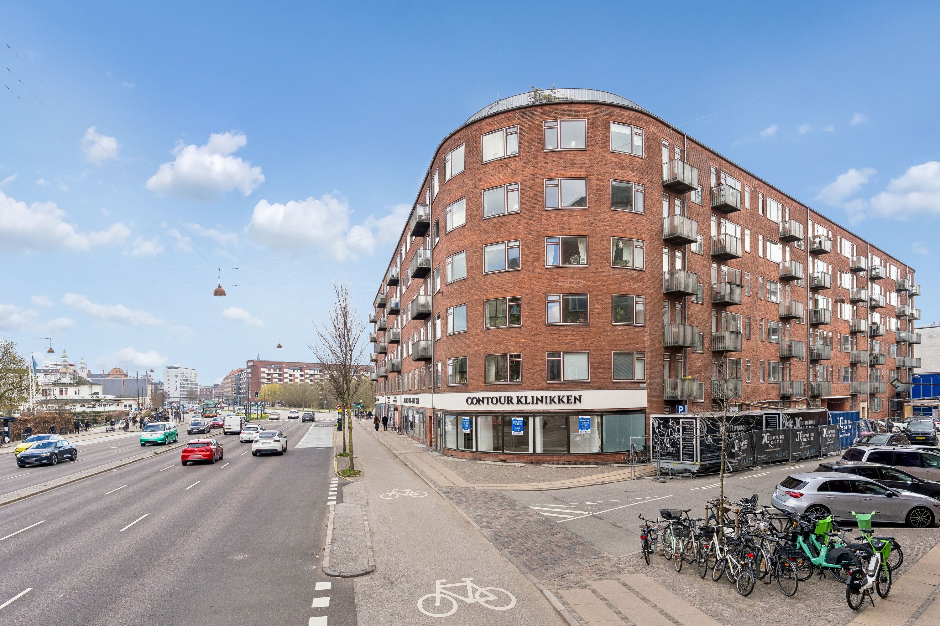 Hjørnebygning med facade ud til Åboulevard 5, 1635 København V. Kontour Klinikken ligger på 1. sal. Parkeringsplads og cykelstier til højre og biler og busser kører på gaden